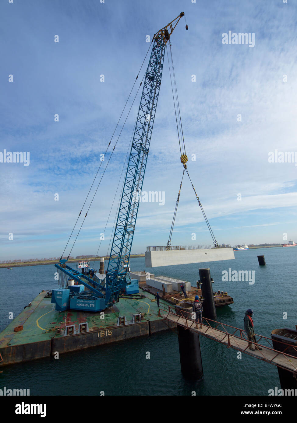 Large floating crane lifting a concrete block into place while building a docking station pier for a large petroleum ship, Botle Stock Photo