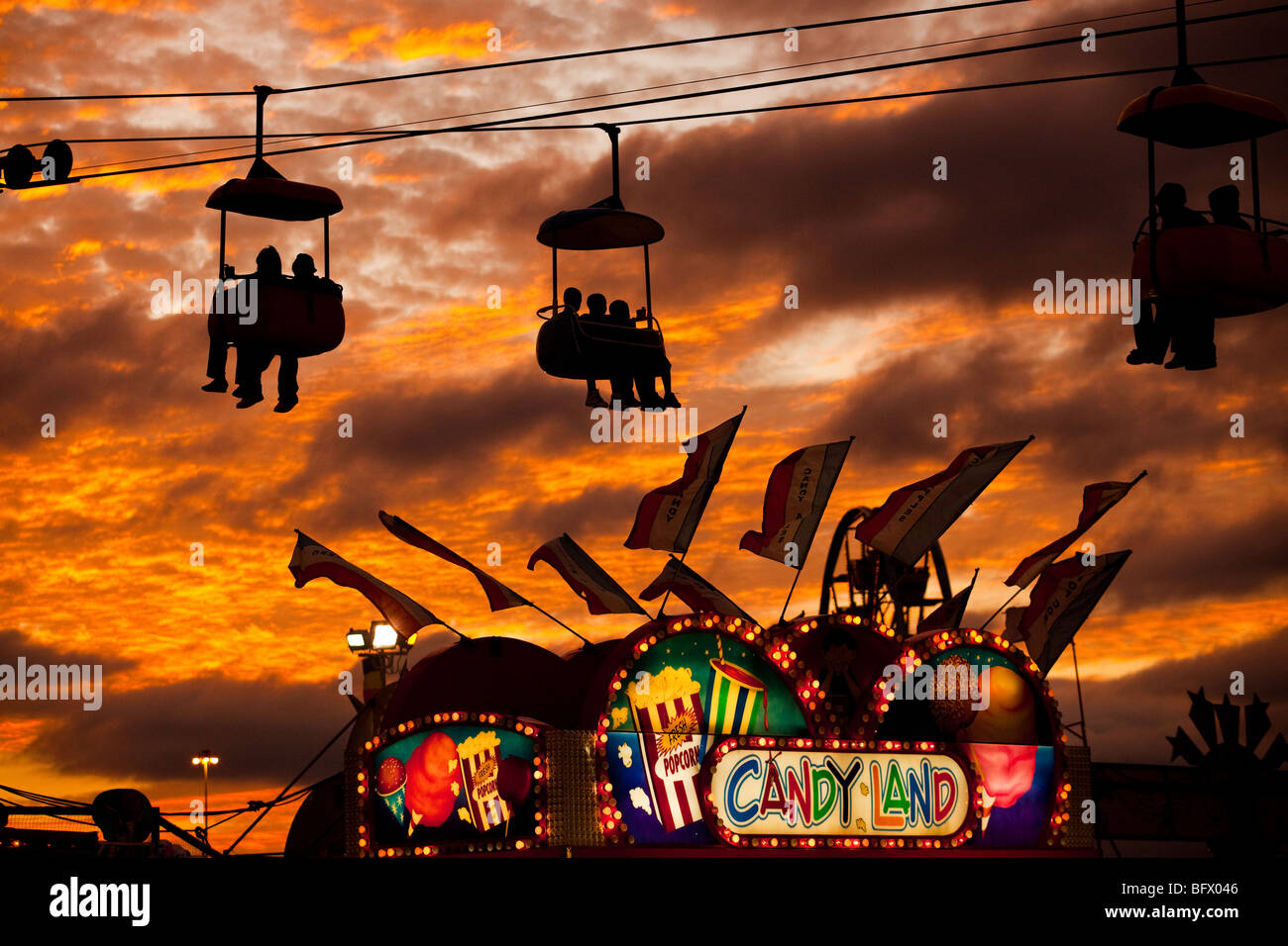 Carnival goers on amusement rides as the sun sets over the Coastal Carolina Fair in Charleston, SC. Stock Photo