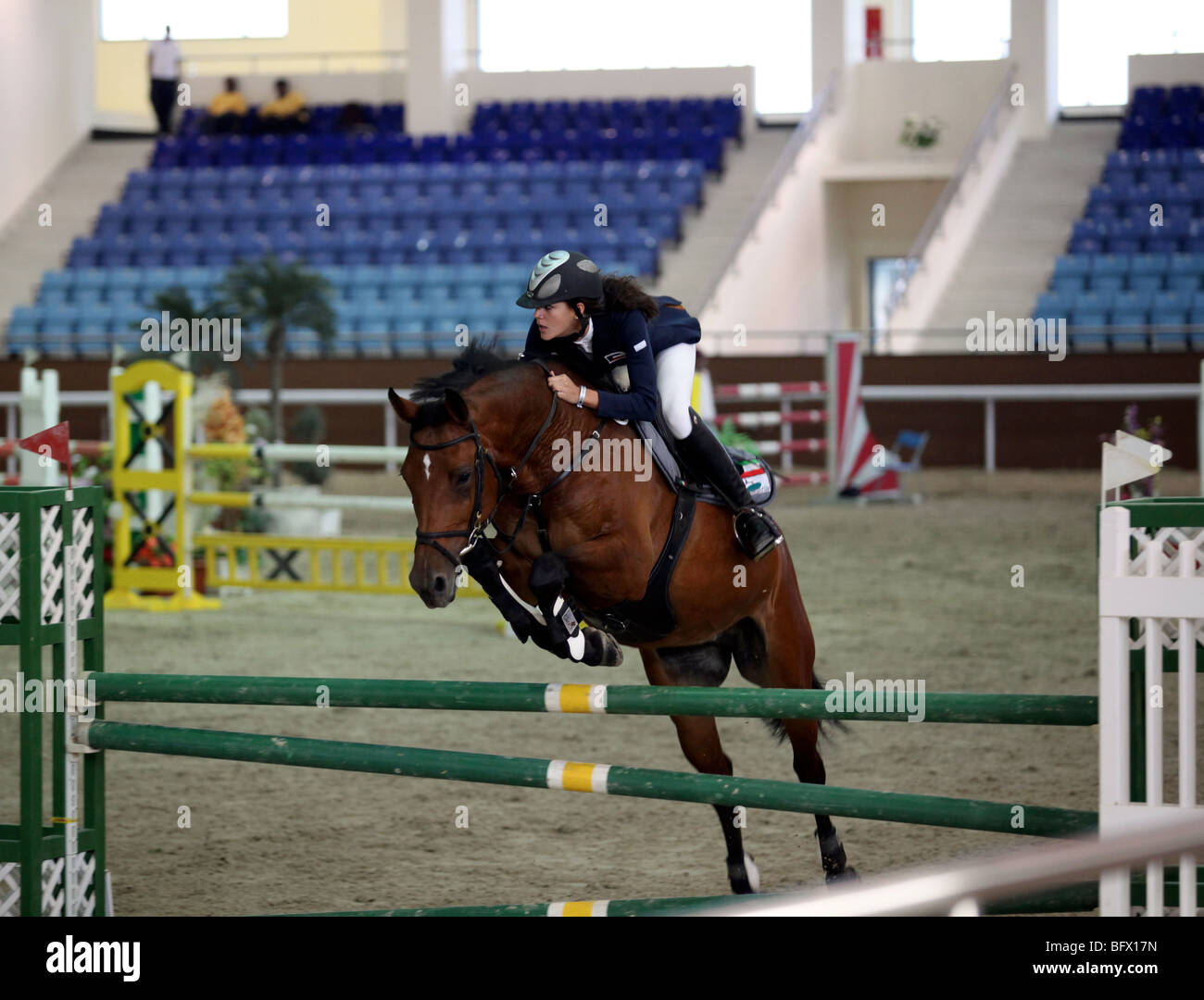 A Kuwaiti woman showjumper in action at a regional competition held at the Qatar Equestrian Federation's indoor arena in Doha Stock Photo