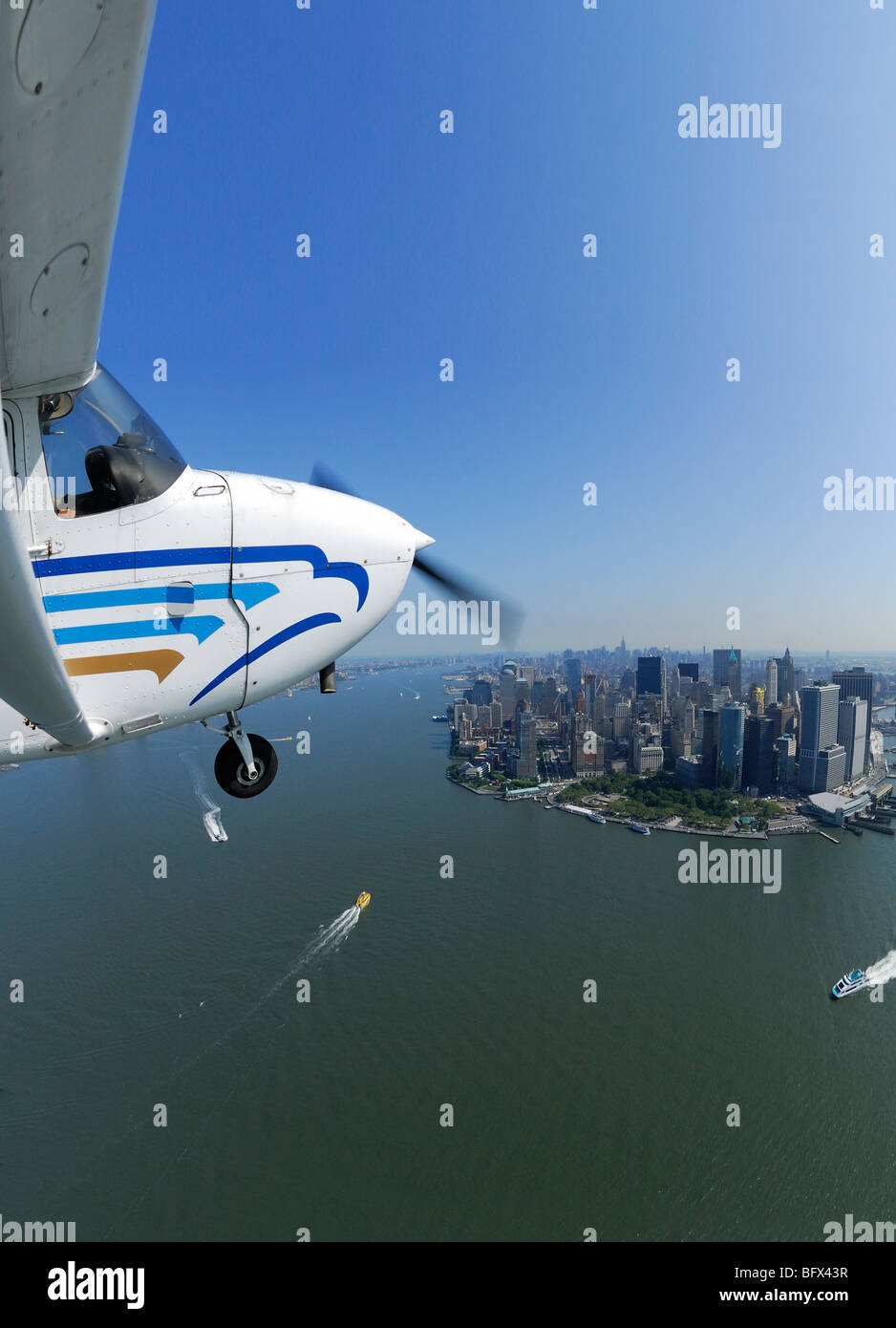 A light plane Cessna 172 flying over Lower Manhattan and Hudson river