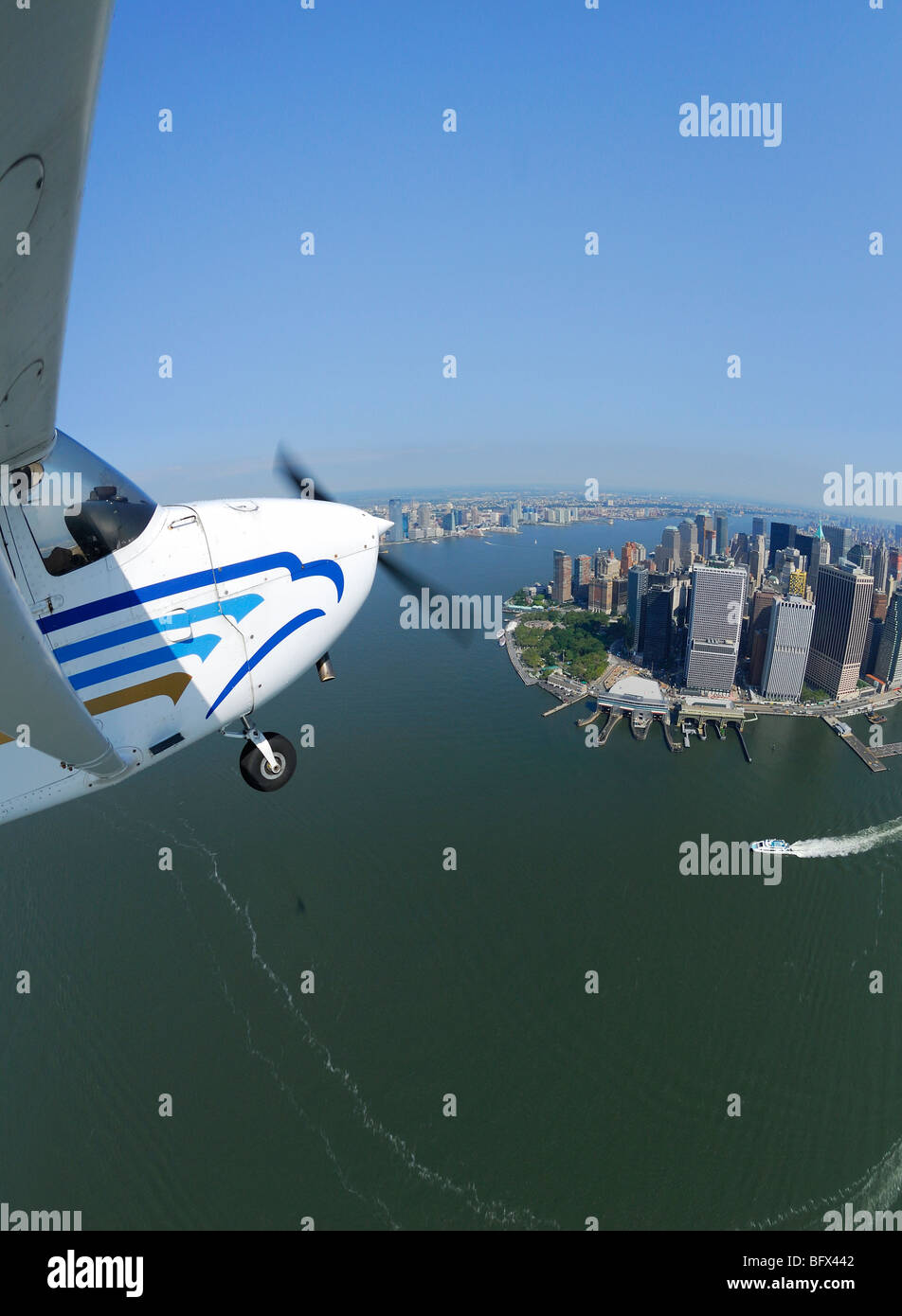 A light plane Cessna 172 flying over Lower Manhattan and Hudson river