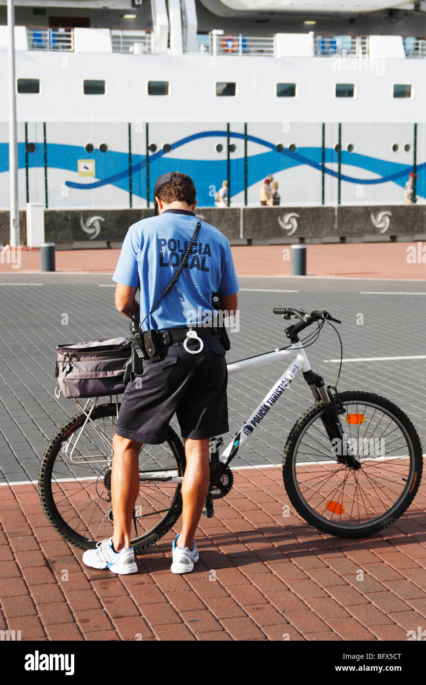 Young Spanish policeman with bike near cruise ship in Las Palmas on Gran Canaria Stock Photo