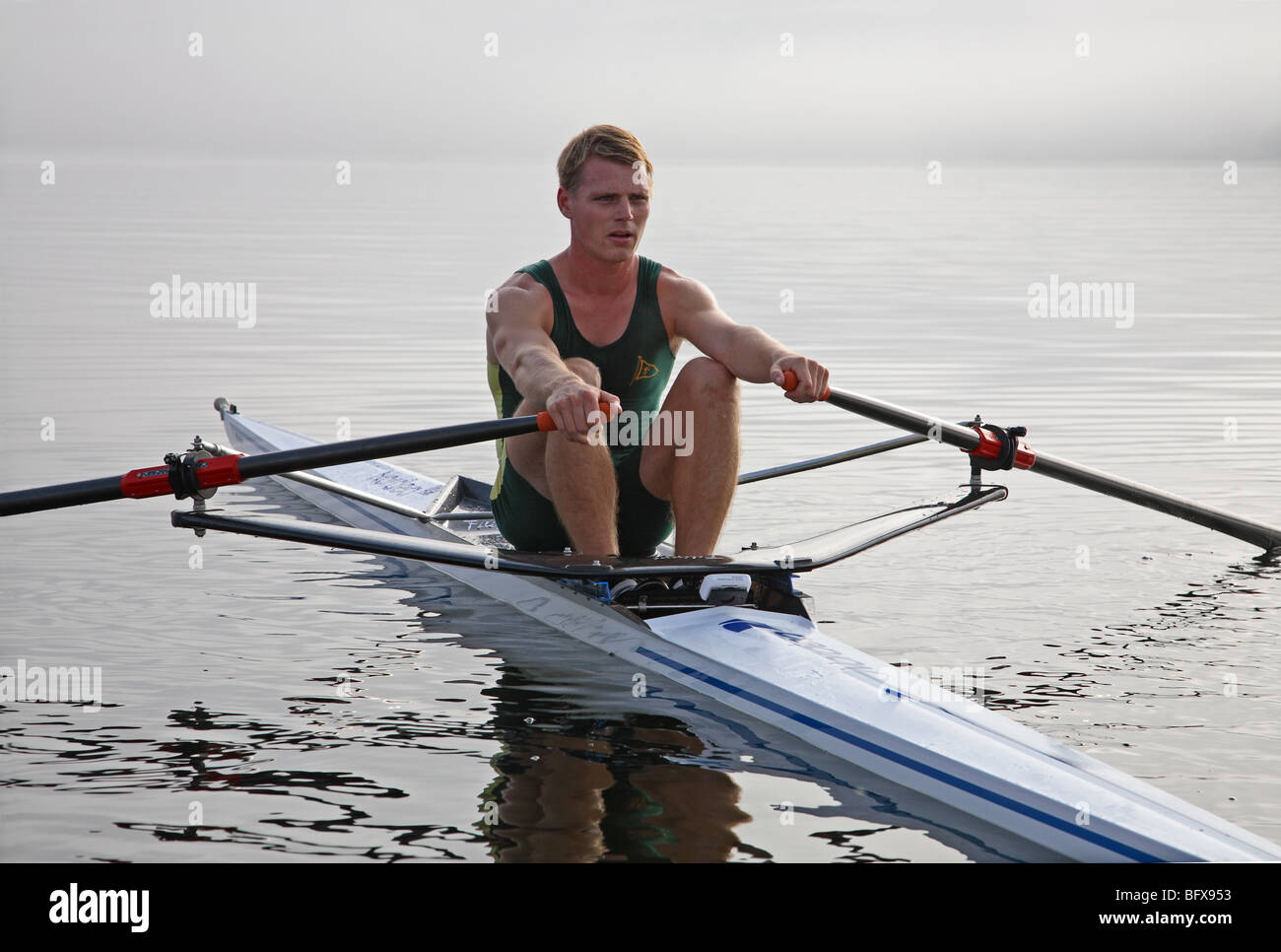 Danish elite rower Henrik Stephansen at a training session in his single-sculler on Lake Furesø on a misty late summer day. Stock Photo