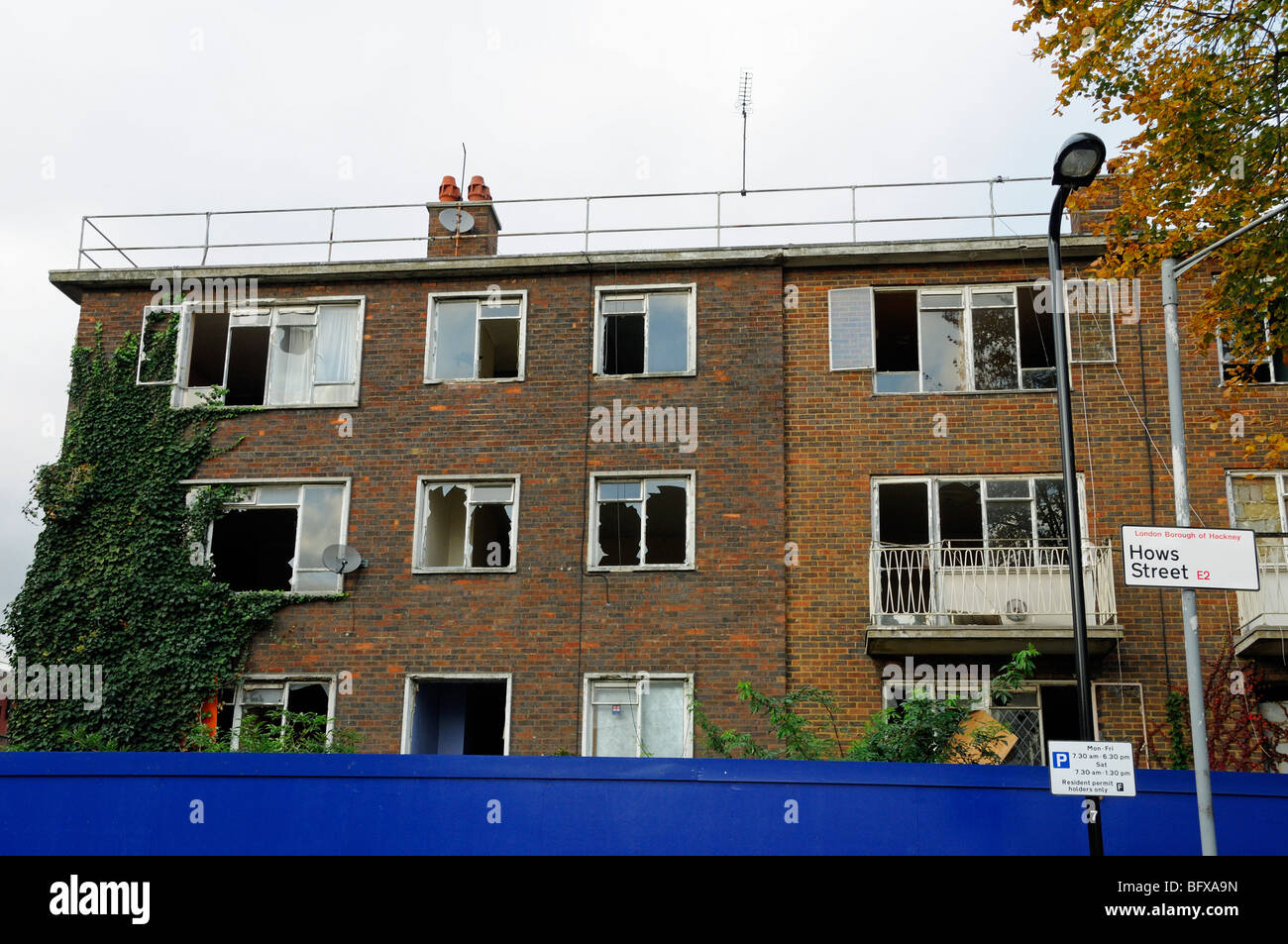 Derelict flats behind hoardings, Hows Street Hackney London England UK Stock Photo