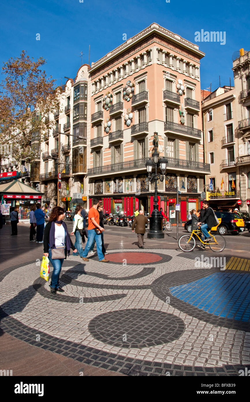 Las Ramblas in Barcelona with pedestrians on Joan Miro mosaic tile design  in front of art deco building formerly an umbrella sh Stock Photo - Alamy
