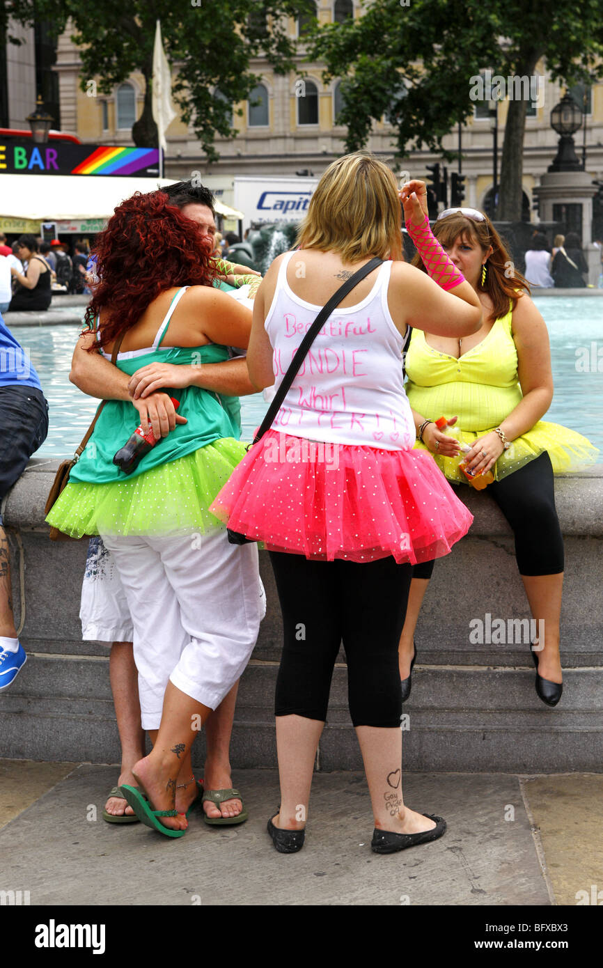 Group of women wearing bright colored tutu skirts in Trafalgar Square London during a hen party Stock Photo