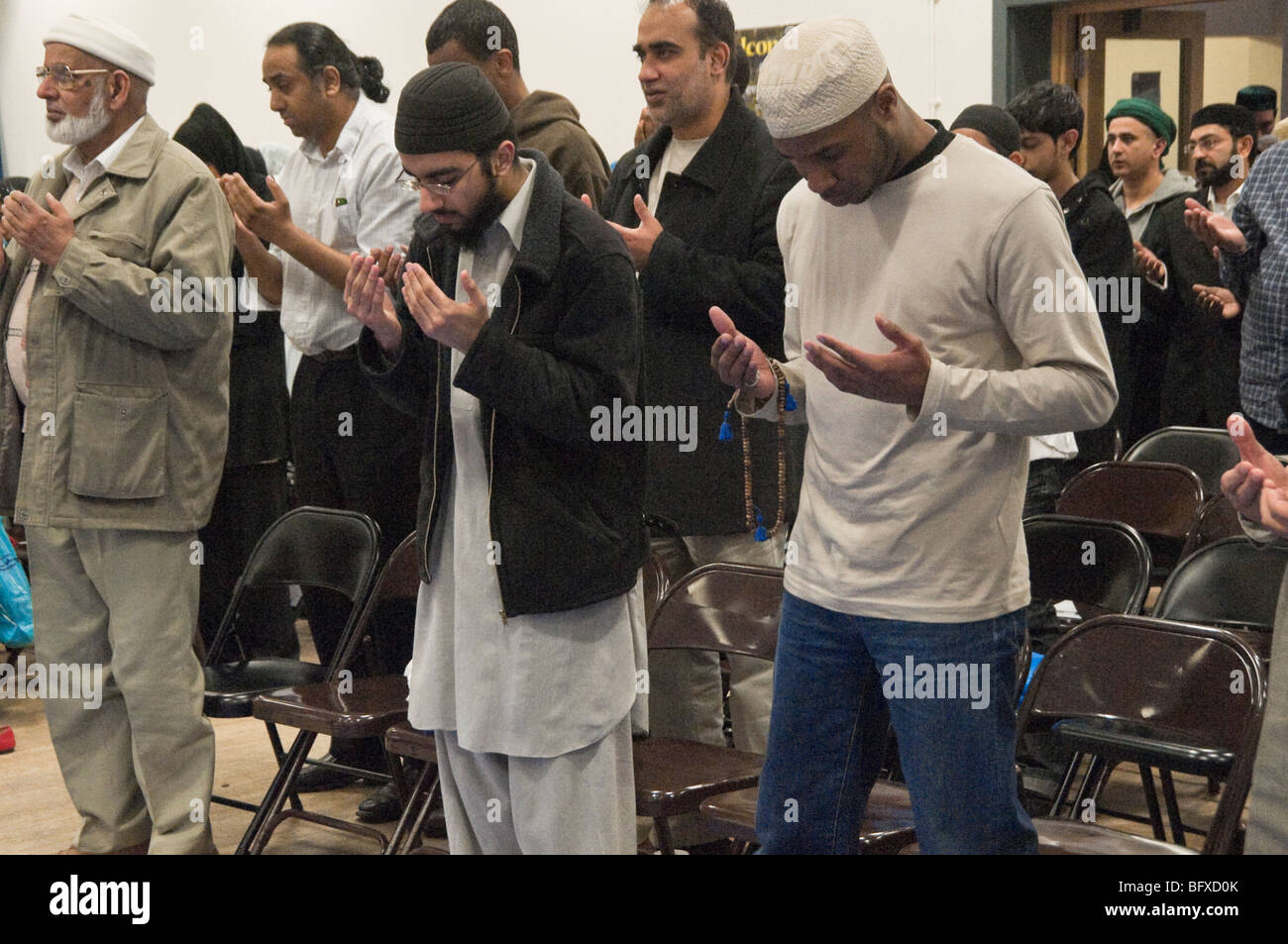 Men standing to pray at Eid Milad-Un-Nabi Celebrations at Sunni Muslim Association, Tooting, London. Stock Photo