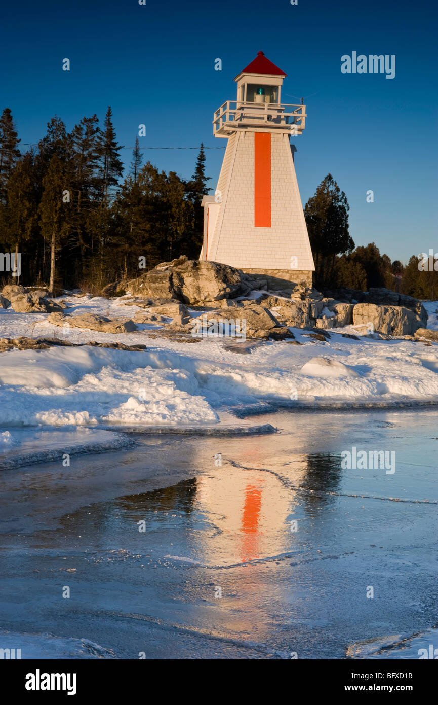 South Bay Lighthouse reflected in ice build-up along Georgian Bay shoreline, South Bay, Manitoulin Island, Ontario, Canada Stock Photo