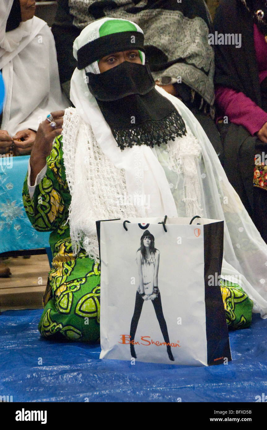 Veiled Muslim woman with fashion shop bag at Eid Milad-Un-Nabi Celebrations at Sunni Muslim Association, Tooting, London. Stock Photo