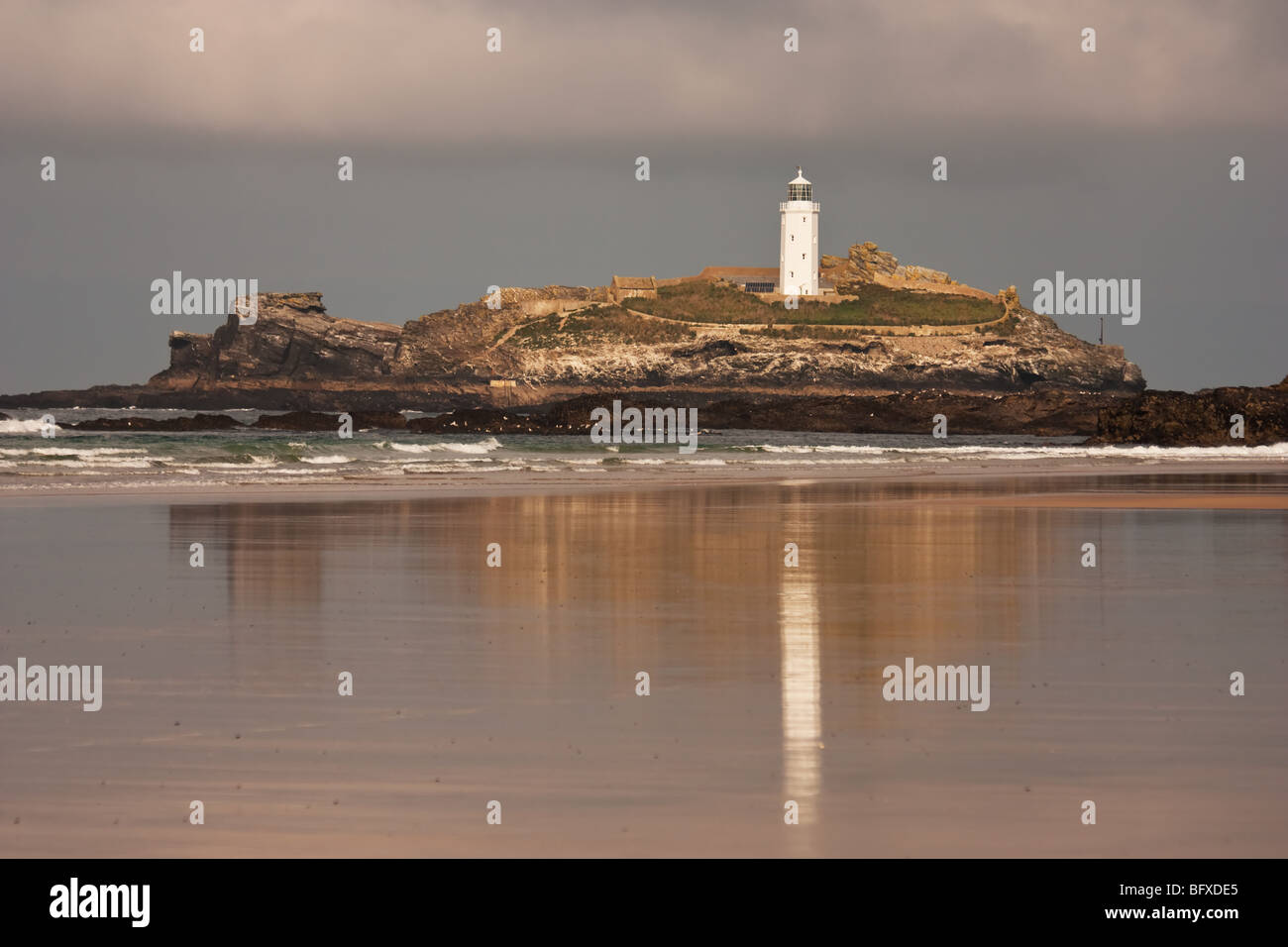 Godrevy lighthouse reflecting across the beach at low tide Stock Photo