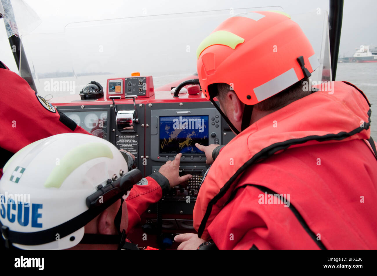 Fire service boat crew look at depth gauge Stock Photo