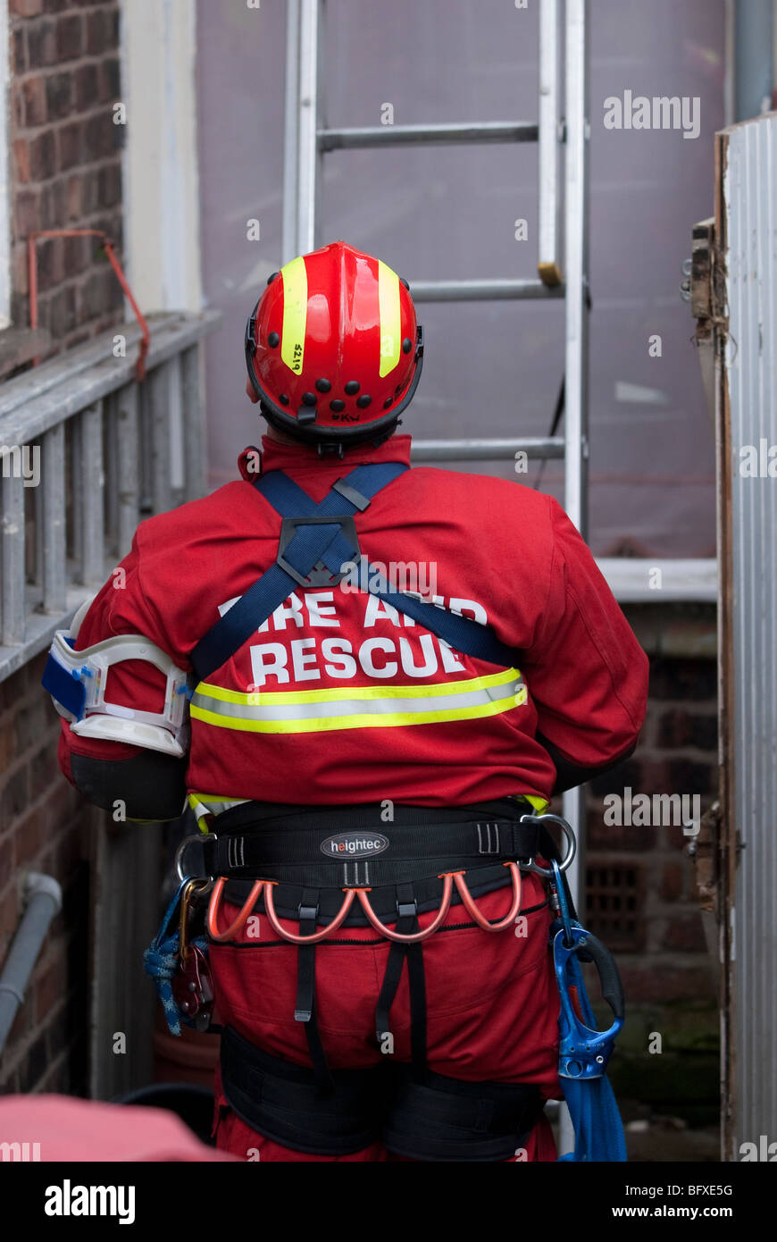 Fire and Rescue USAR in Rope Access Gear ascends ladder Stock