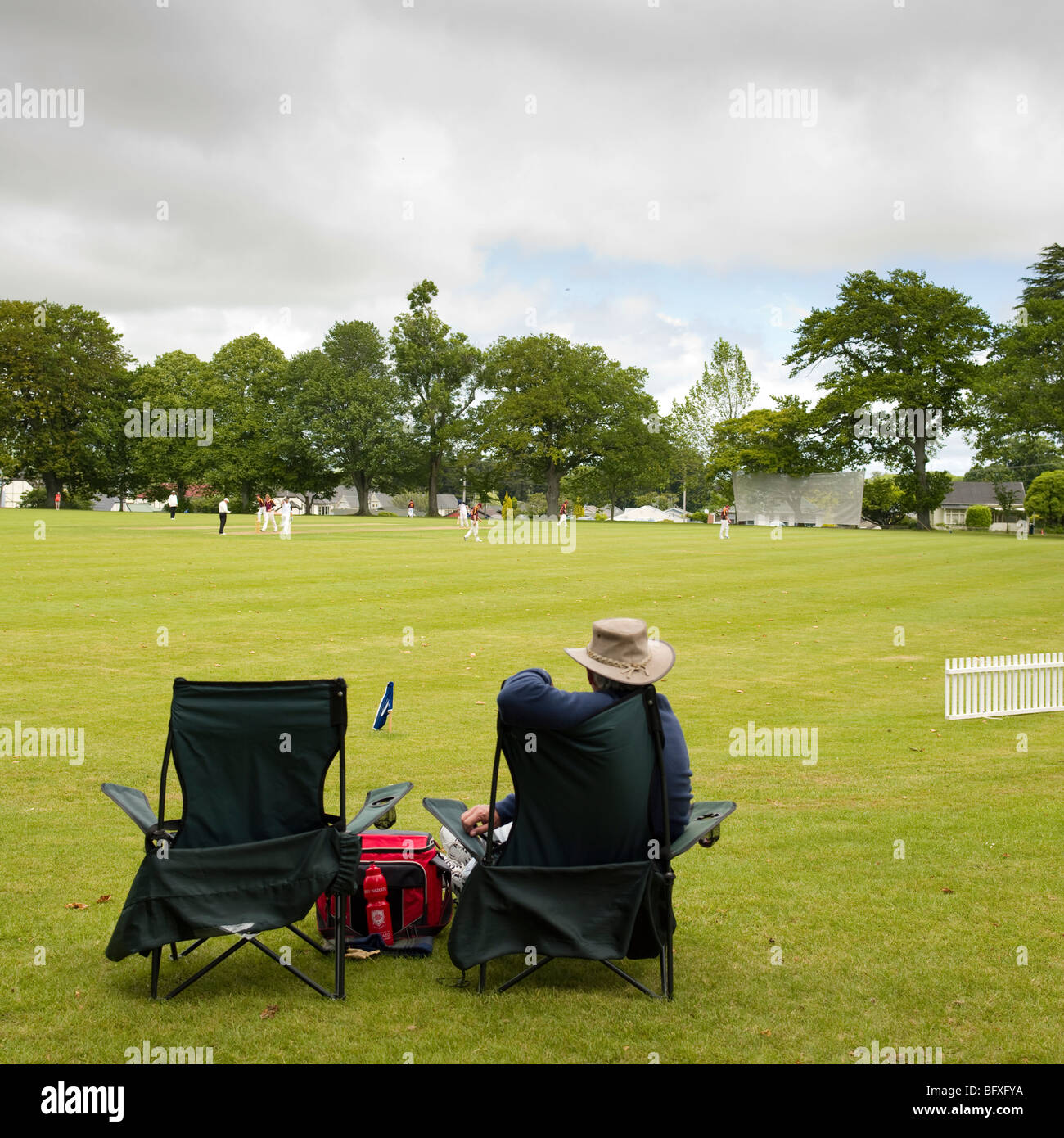 man sitting in folding chairs watching cricket match Stock Photo Alamy