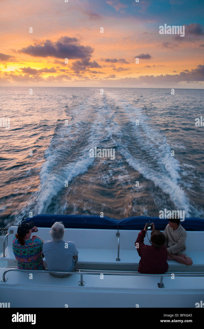 Tourists watching the sunrise while on tour boat, Kauai, Hawaii Stock ...
