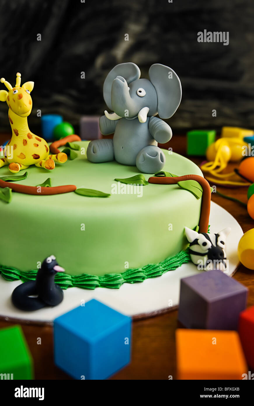 Jungle themed birthday cake with an elephant and giraffe on top, surrounded by building blocks. Stock Photo