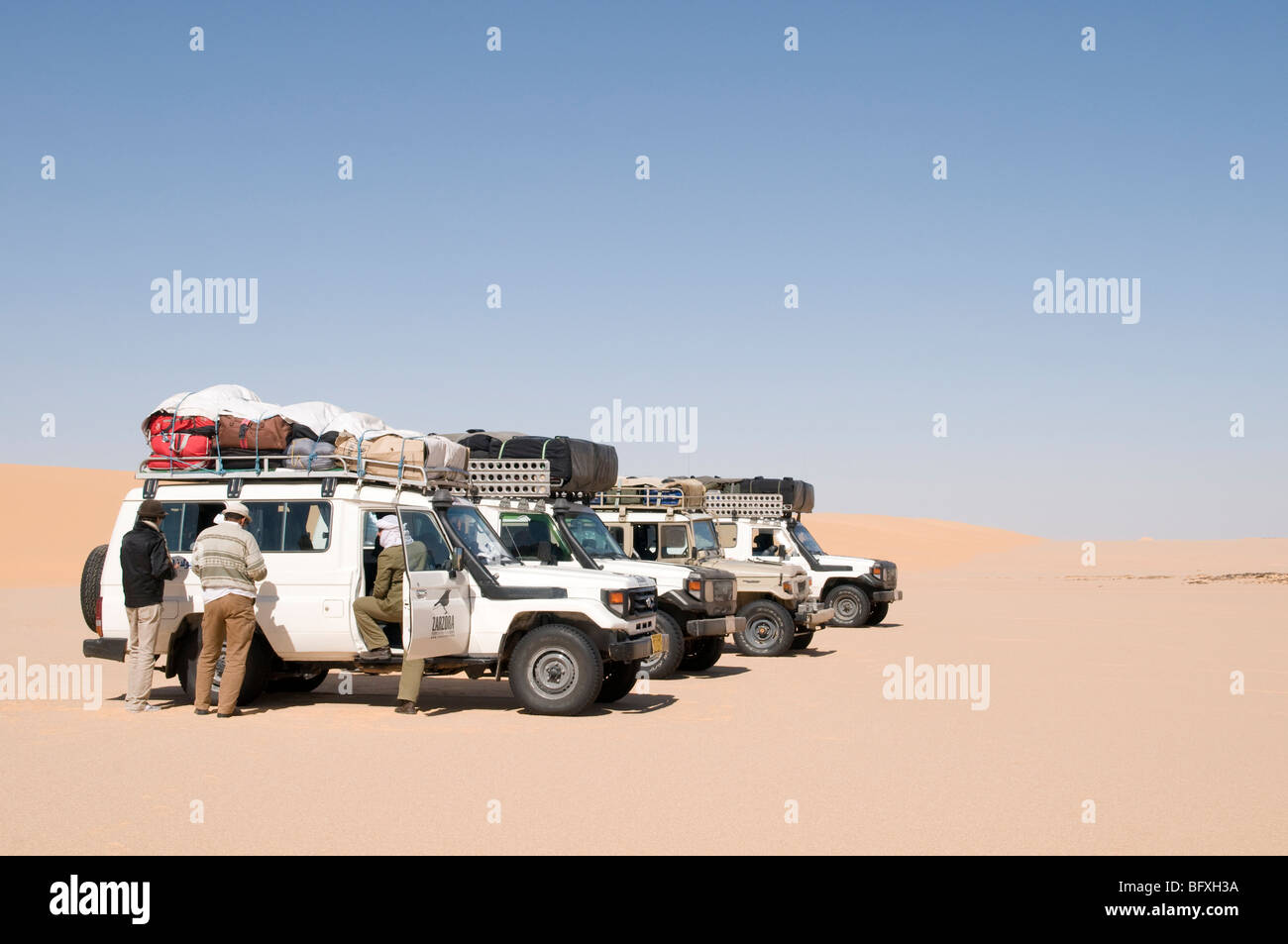 A convoy of Sahara desert safari 4x4 jeeps on the edge of the Great Sand Sea deep in the Western Desert Sahara region of Egypt. Stock Photo