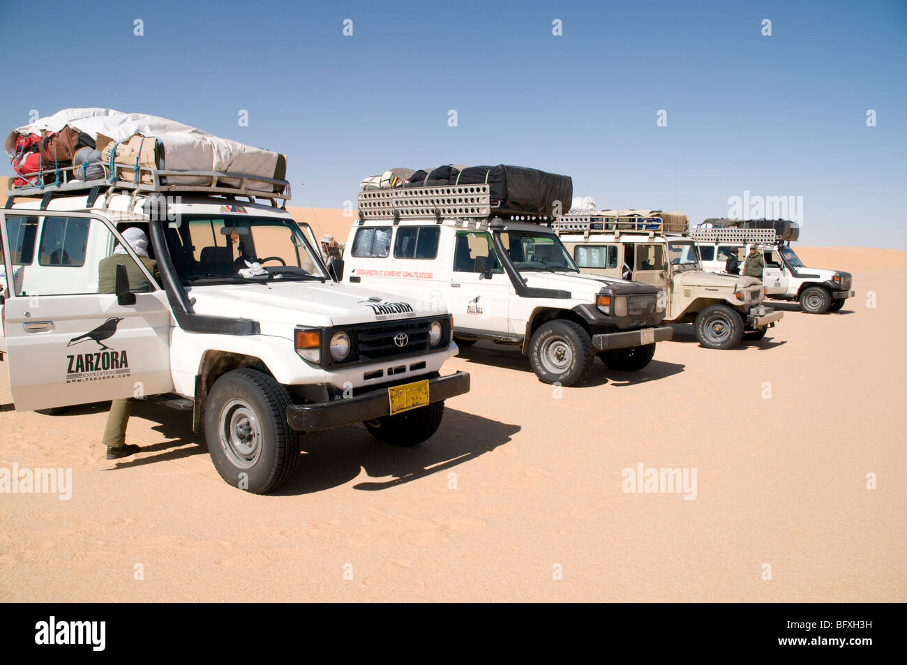 A convoy of Sahara desert safari 4x4 jeeps on the edge of the Great Sand Sea deep in the Western Desert Sahara region of Egypt. Stock Photo