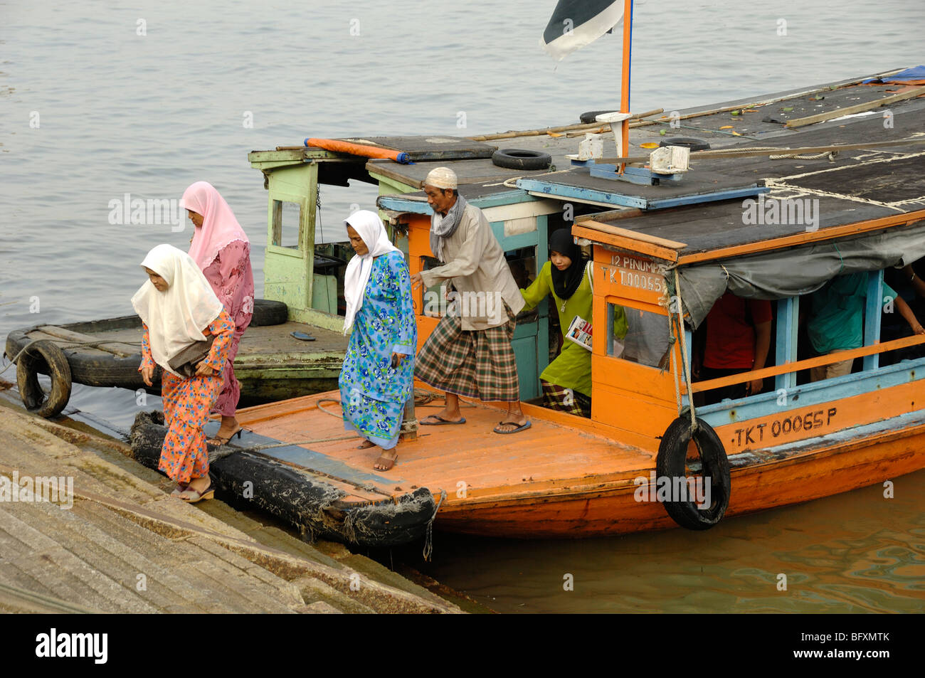 Malay or Malaysian Muslim Women in Islamic Dress Leave a Ferry Boat on the Waterfront at Kuala Terengganu, Malaysia Stock Photo