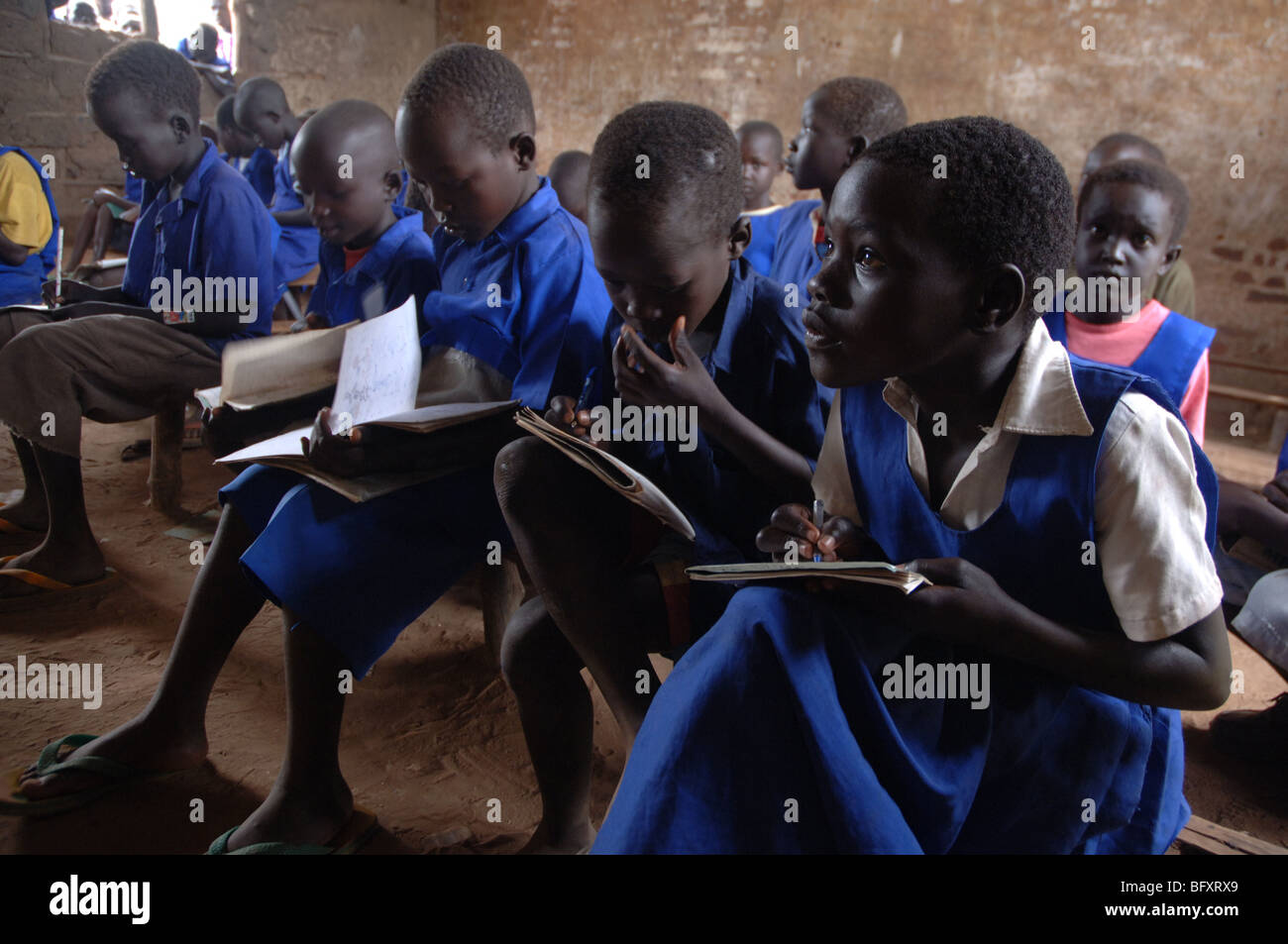 Pupils learning at a school classroom that has been scarred by thousands of bullets during the 34 year war in Yei, Sudan. Stock Photo