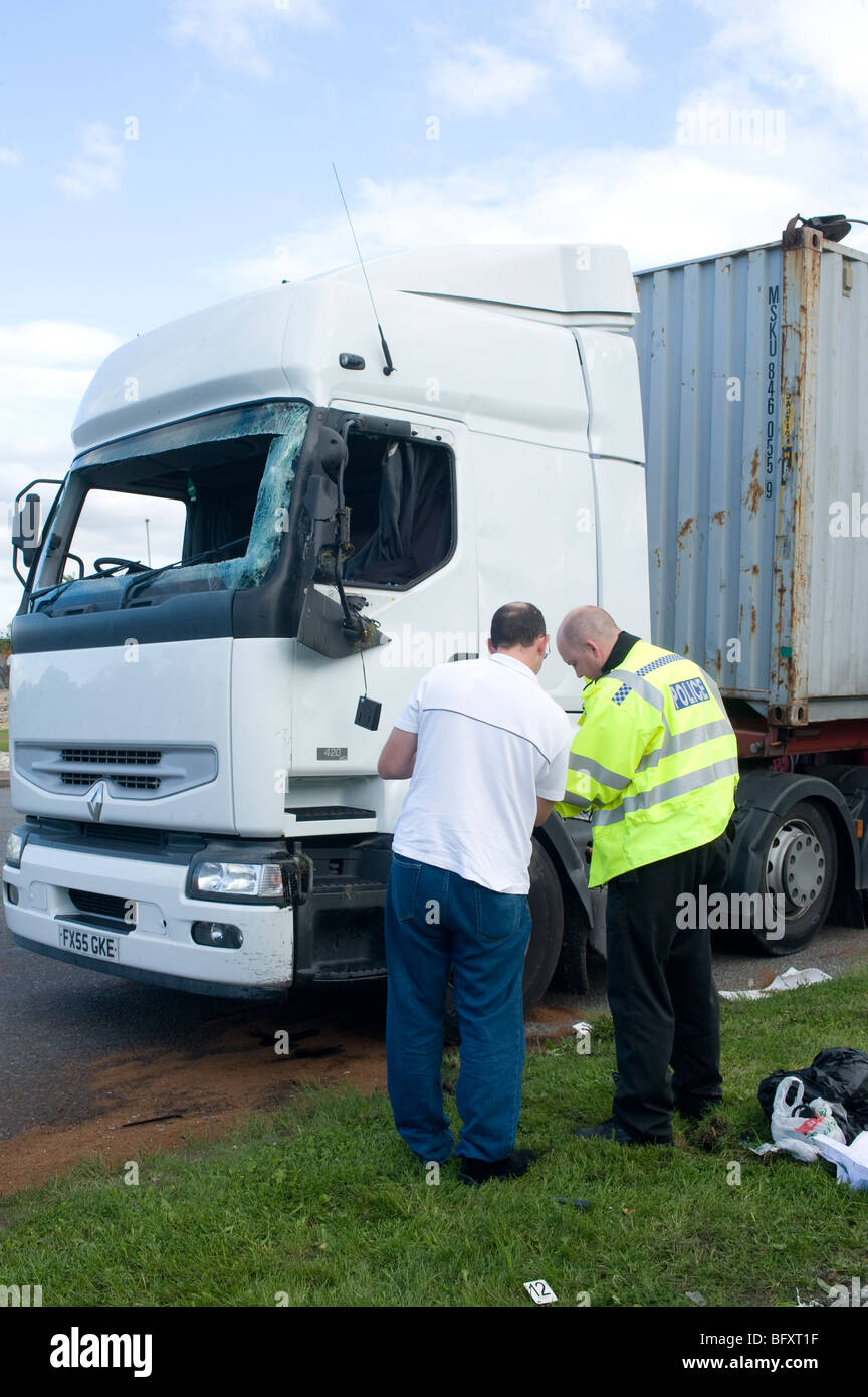 Policeman interviewing a witness following a lorry crash on an English road. Stock Photo