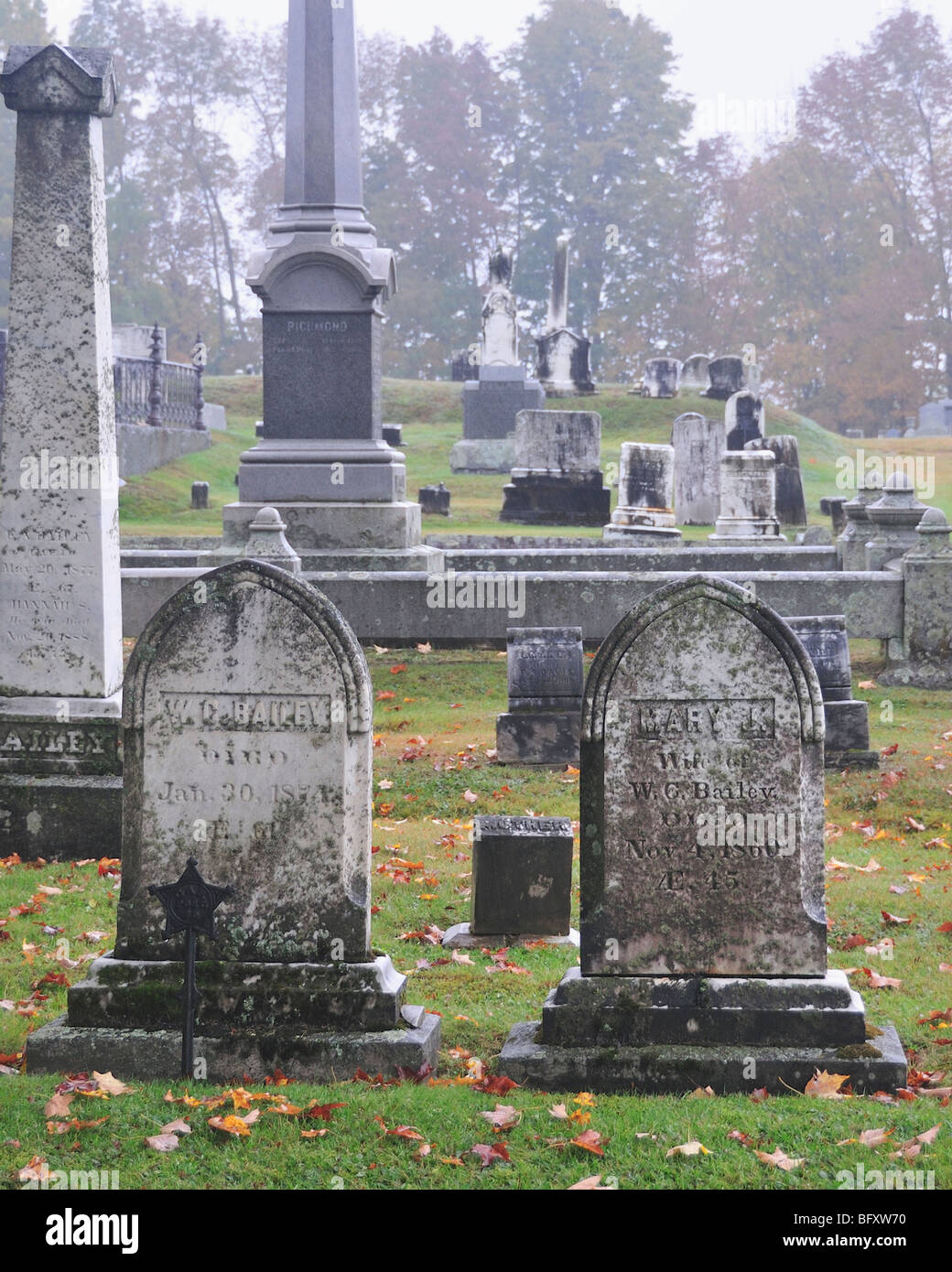 Autumn rain and fog lends a spooky atmosphere to the mossy gravestones in an old 1800s cemetery in Maine, USA. Stock Photo