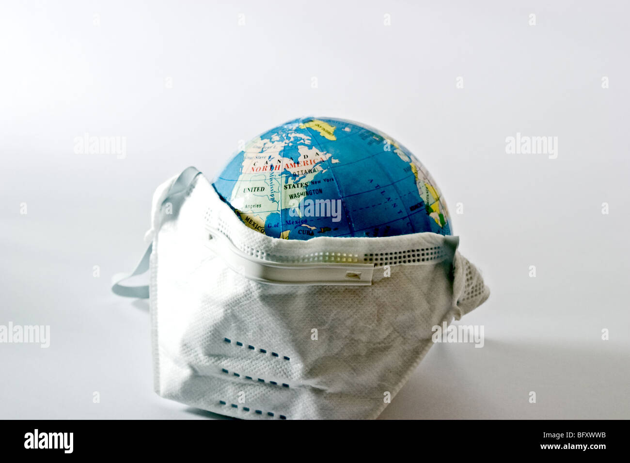 Medical mask covering a representation of the earth Stock Photo