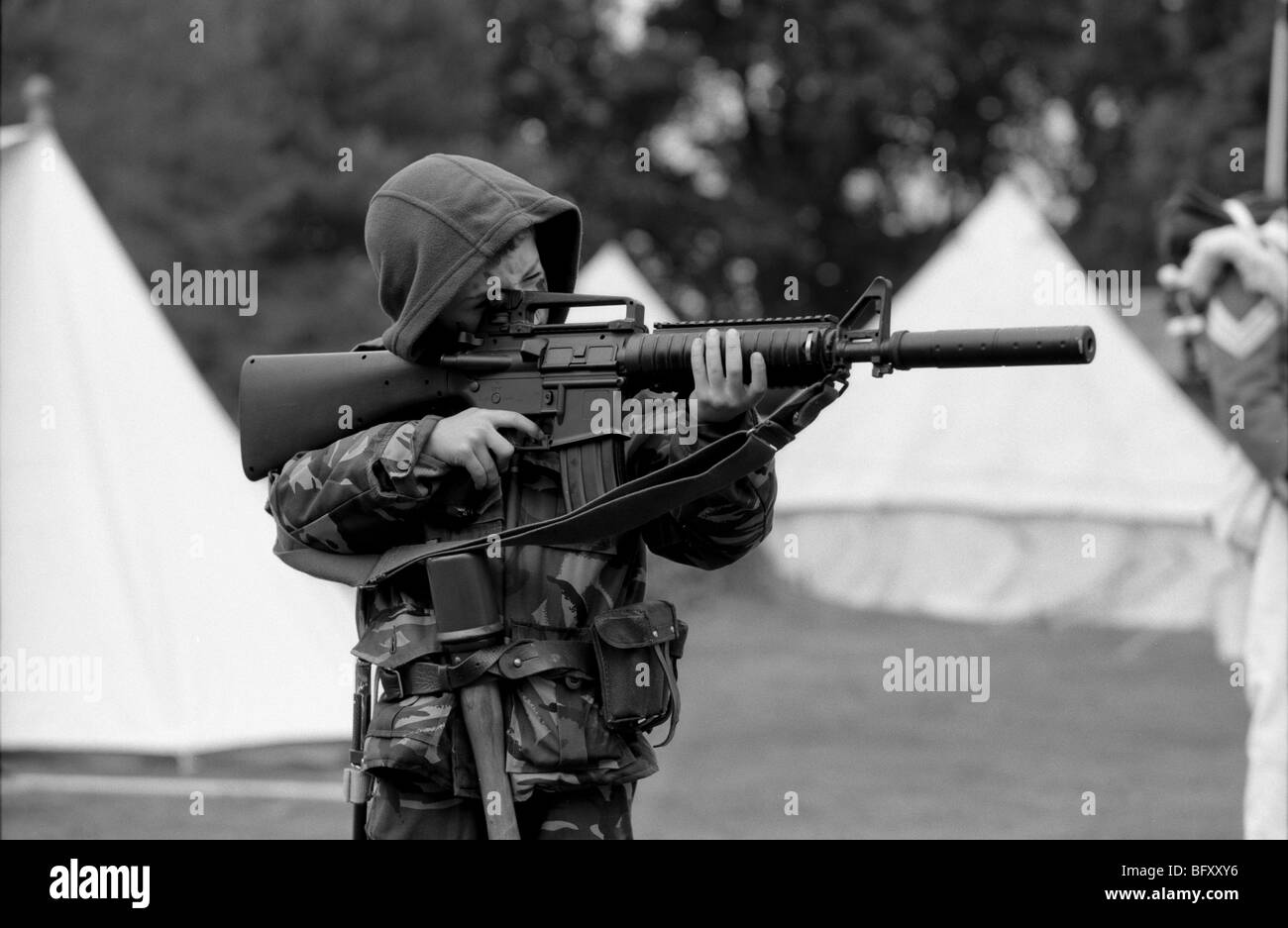 Young boy in full combat dress and armed with M16 assault rifle Stock Photo