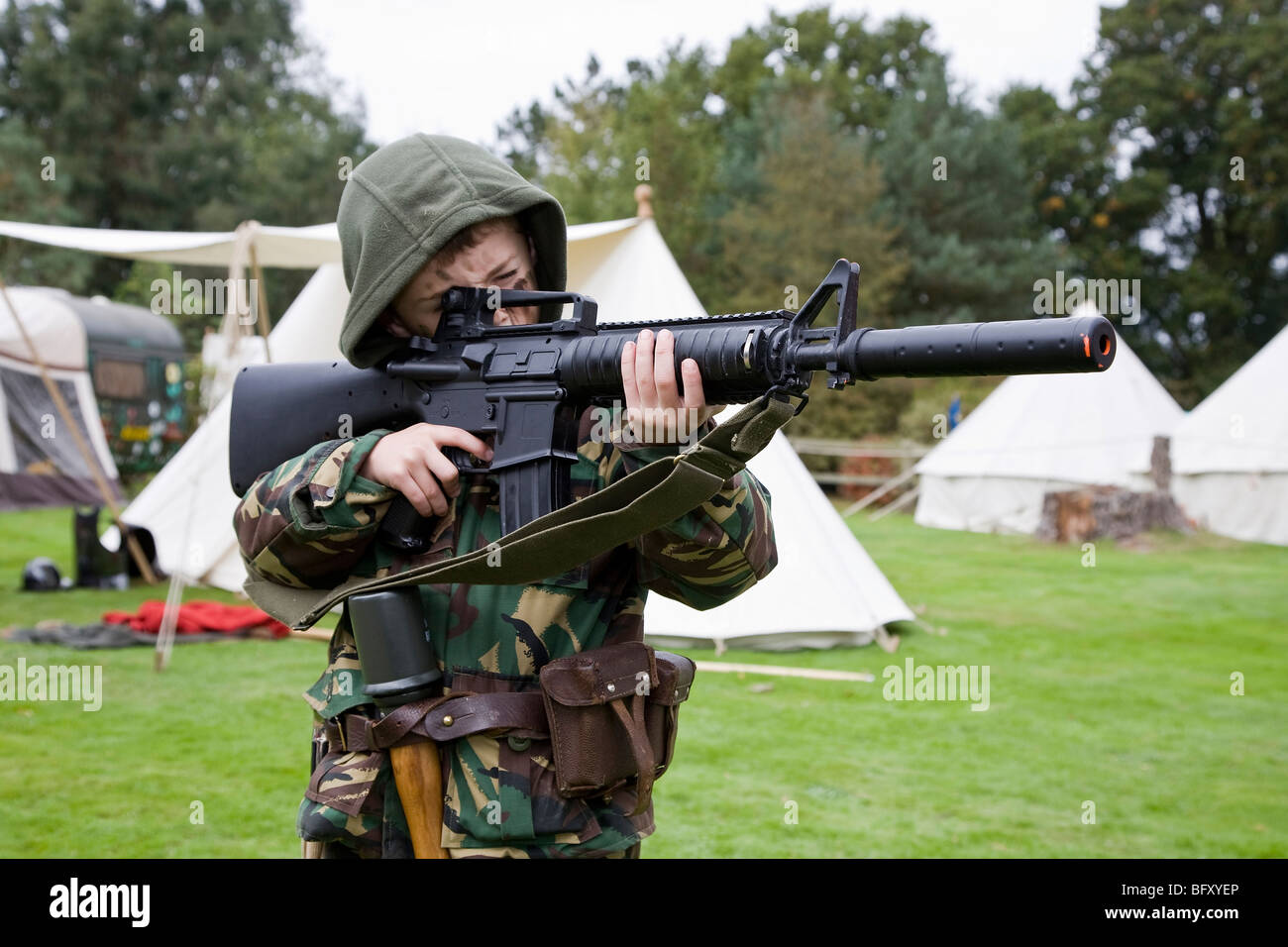 Young boy in full combat dress and armed with M16 assault rifle Stock Photo
