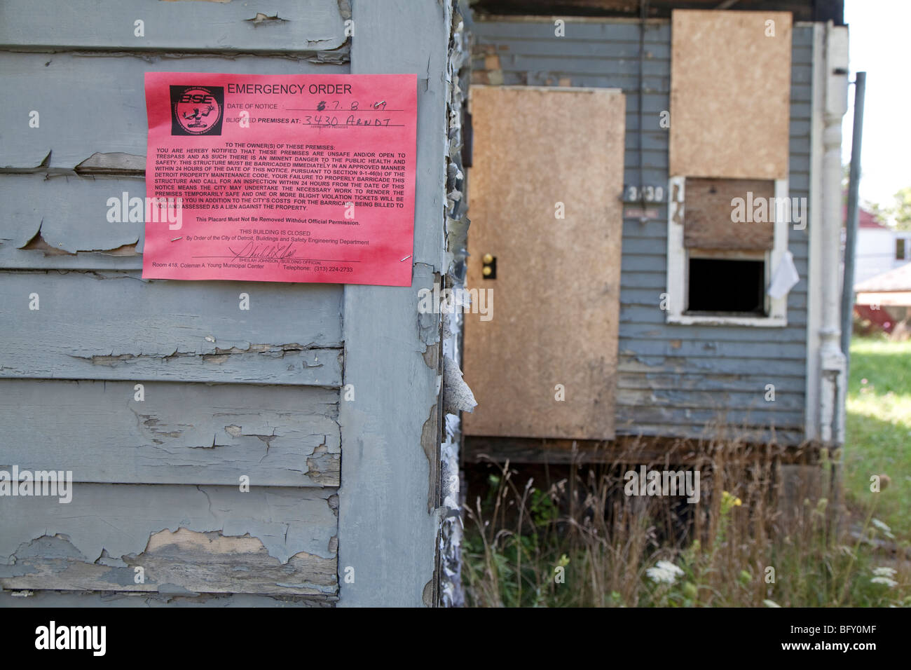 A vacant home on Detroit's east side with an emergency order posted by city inspectors declaring it unsafe. Stock Photo