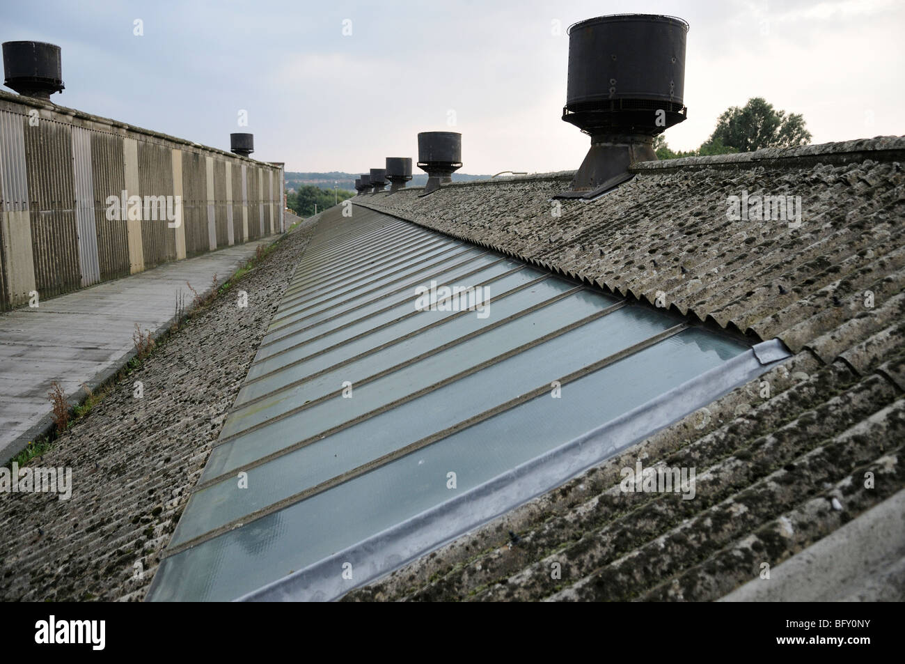 Long factory roof made of asbestos cement sheeting showing roof vents