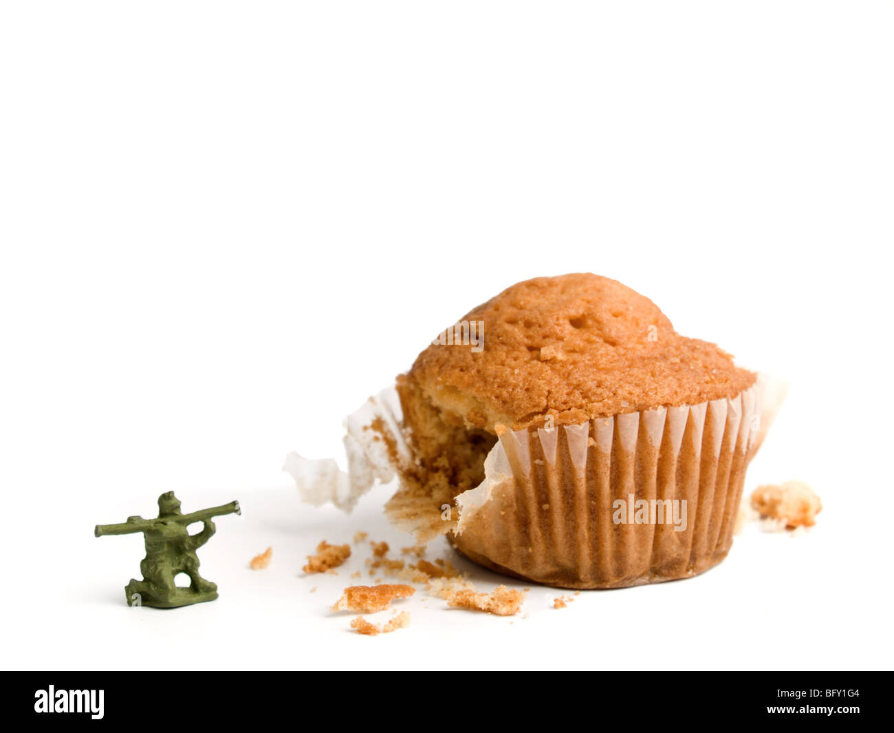 A little toy soldier shooting his bazooka at a muffin. A conceptual image about the importance of a haelthy lifestile. Stock Photo