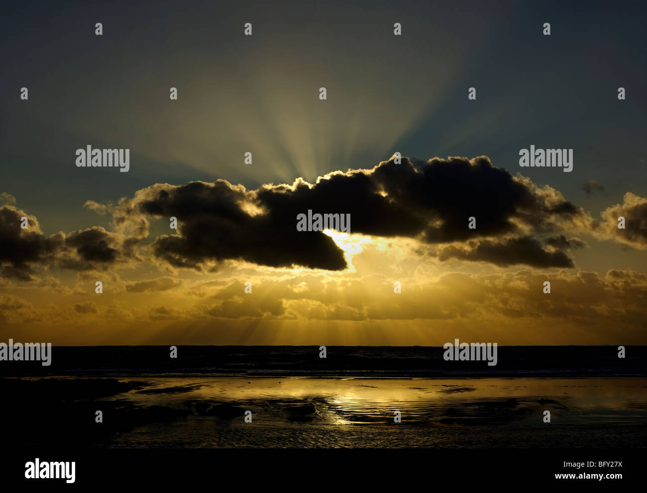 Streaks of Sunlight behind Clouds with Reflections on the Sea Stock Photo