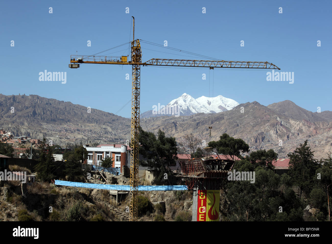 Crane on Puente de los Trillizos suspension bridge construction site, Mt Illimani in background, La Paz, Bolivia Stock Photo