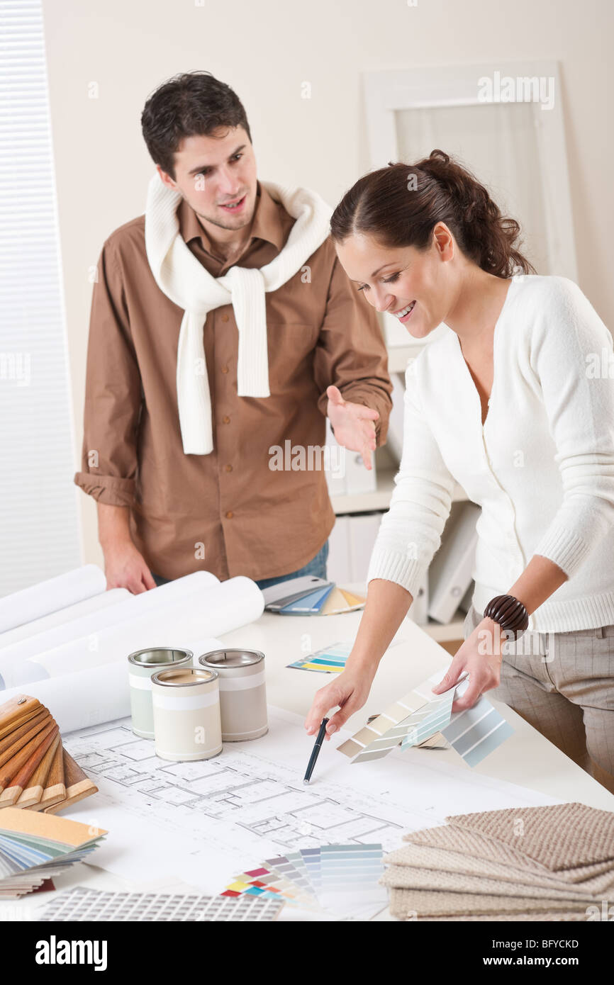Two successful interior designer working at office with color swatch and can of paint Stock Photo