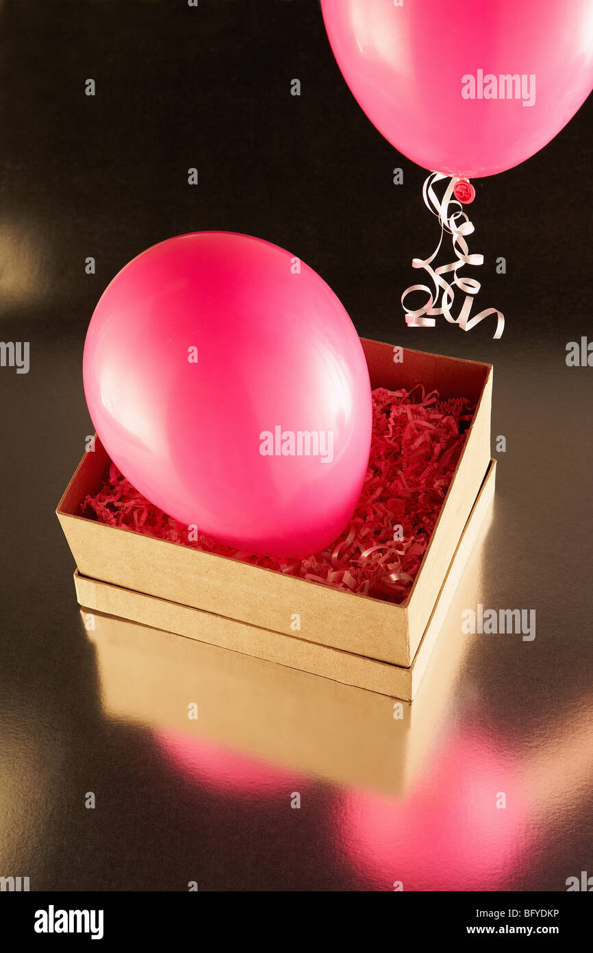 Cardboard box with pink party balloons Stock Photo