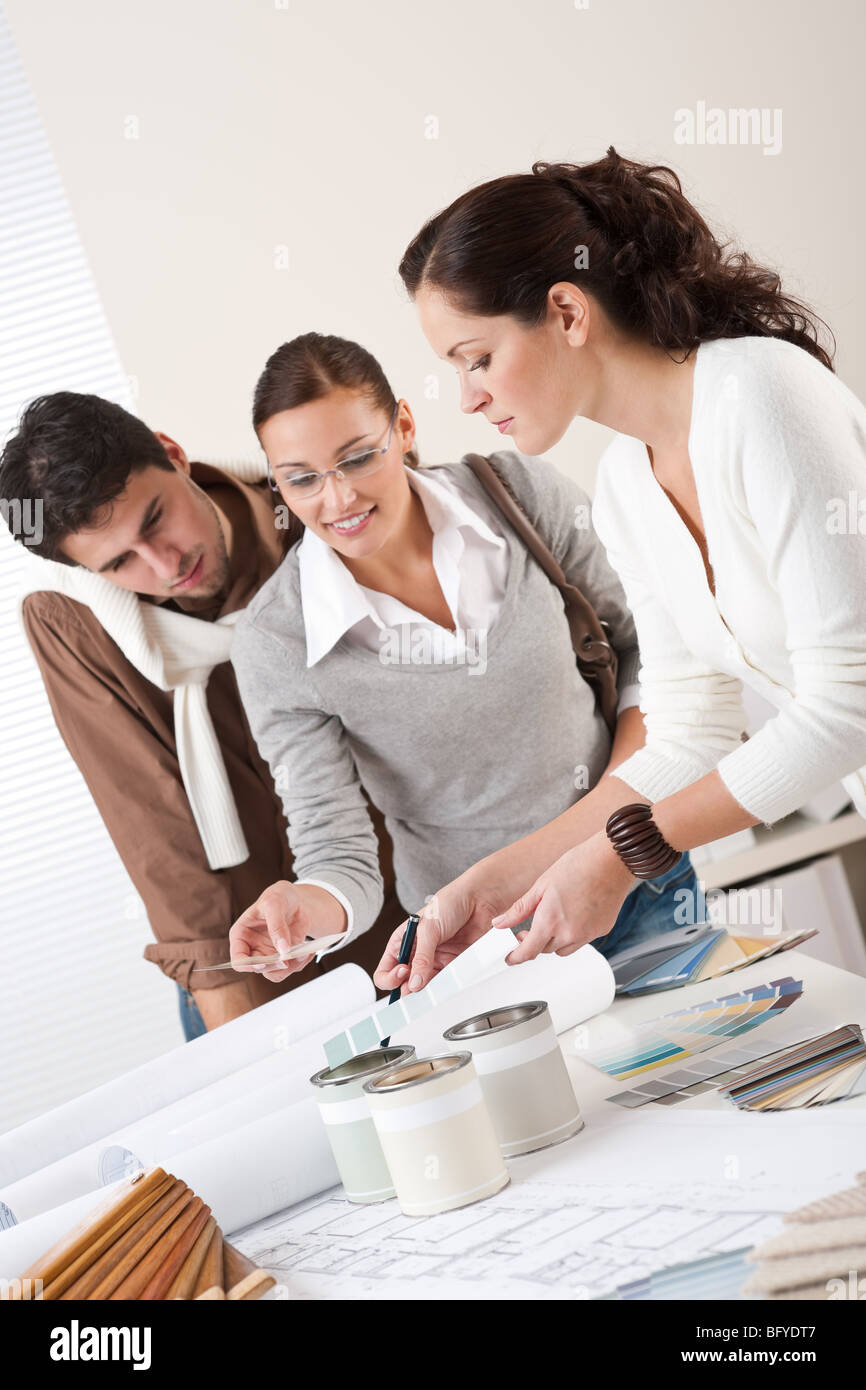 Young successful interior designer woman with two clients at office ...