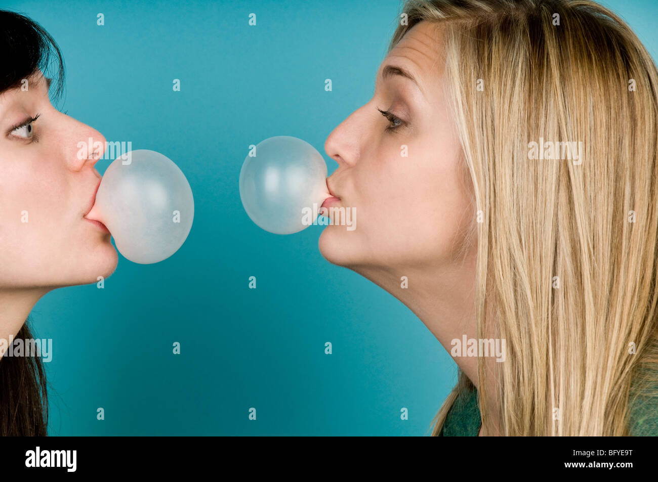 Women blowing bubbles with gum Stock Photo
