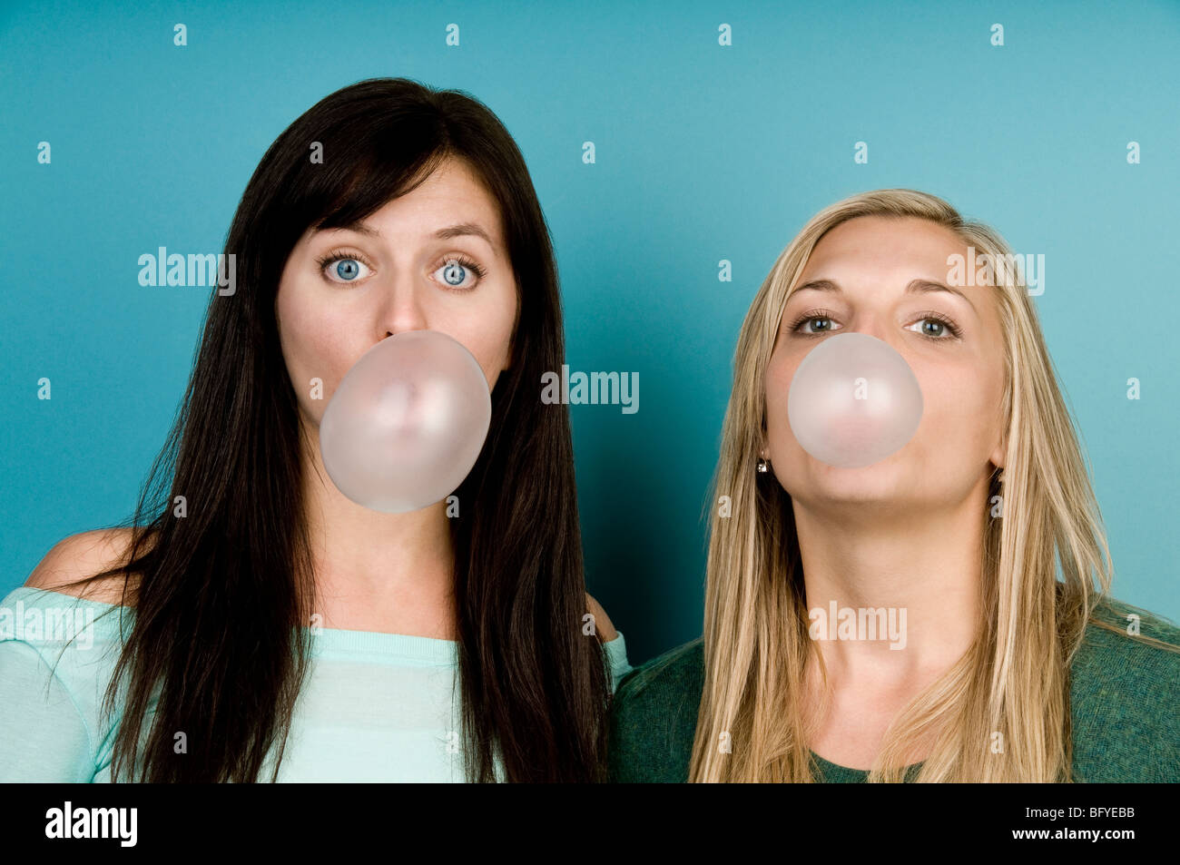 Women blowing bubbles with gum Stock Photo