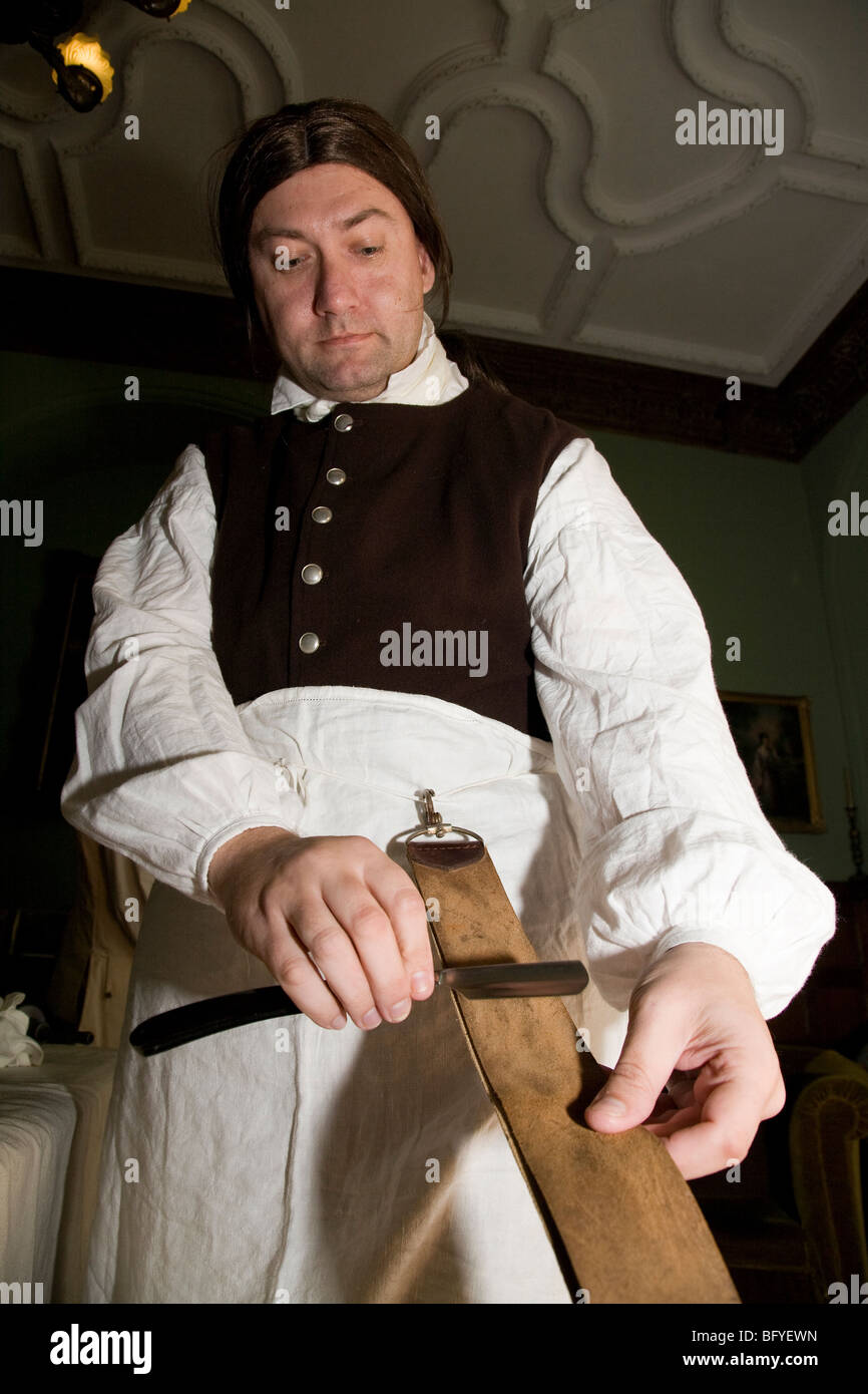 Eighteenth century barbersurgeon sharpening his scalpel Stock Photo