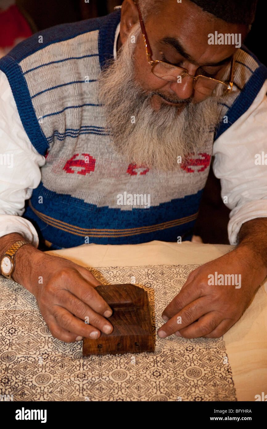 Indian man printing the back of a fabric with a wooden stamp Stock Photo