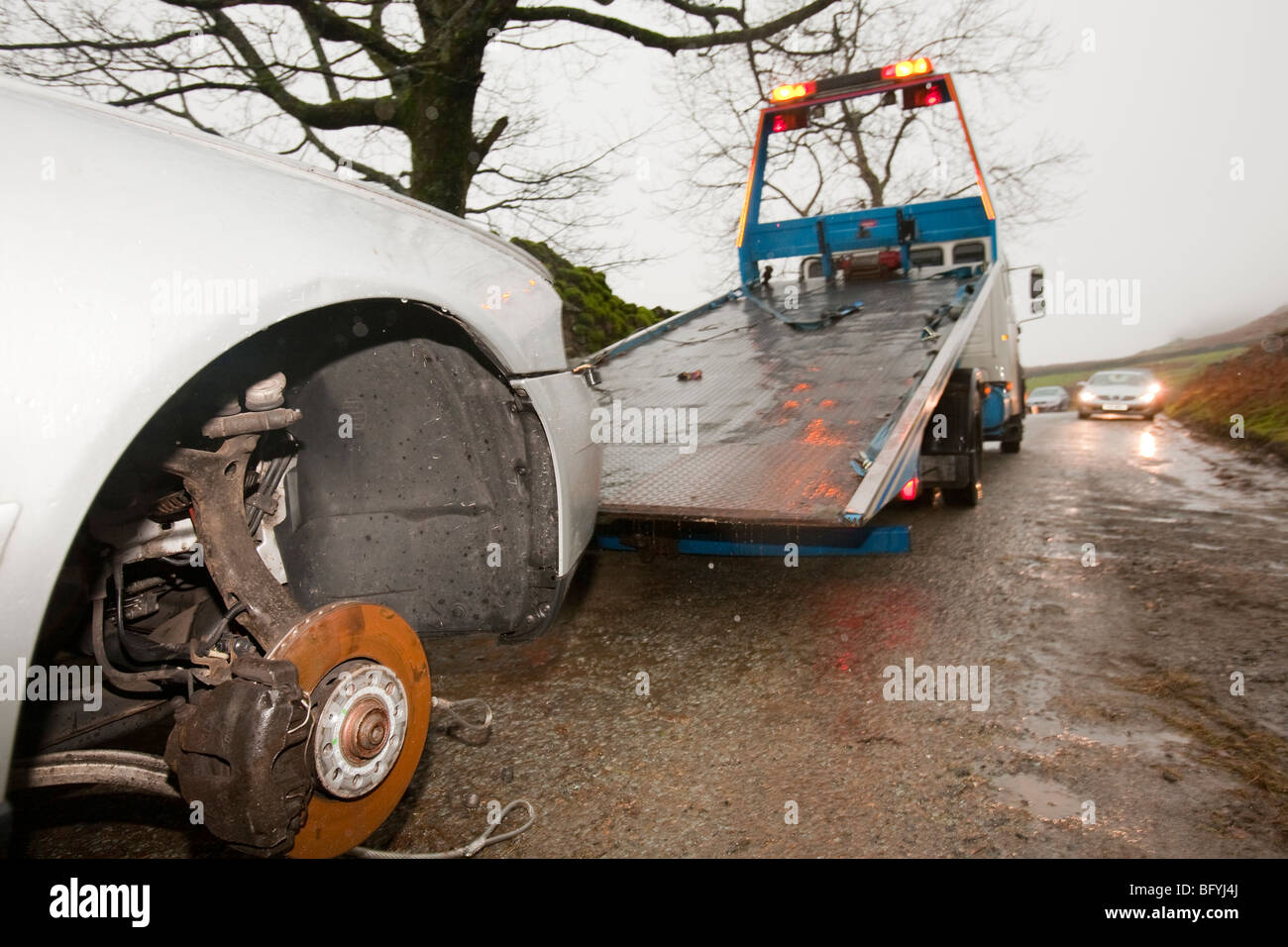 Recovering a car that had its wheels stolen after being abandoned in flood waters near Ambleside, Cumbria, UK. Stock Photo