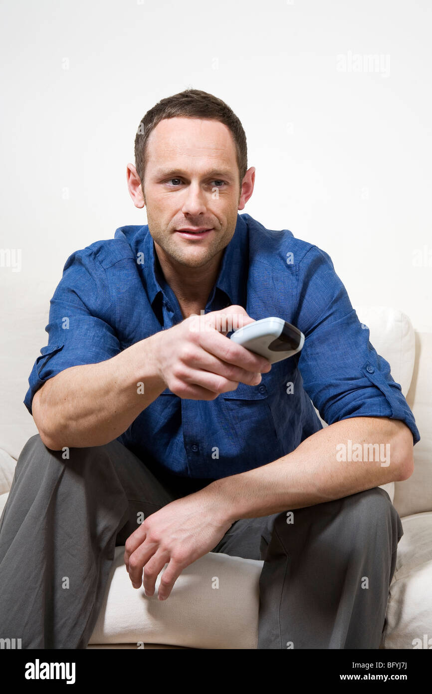 Man watching television in his living room Stock Photo - Alamy