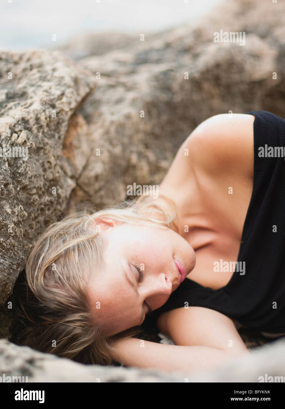 woman lying on rocks at cliffs Stock Photo
