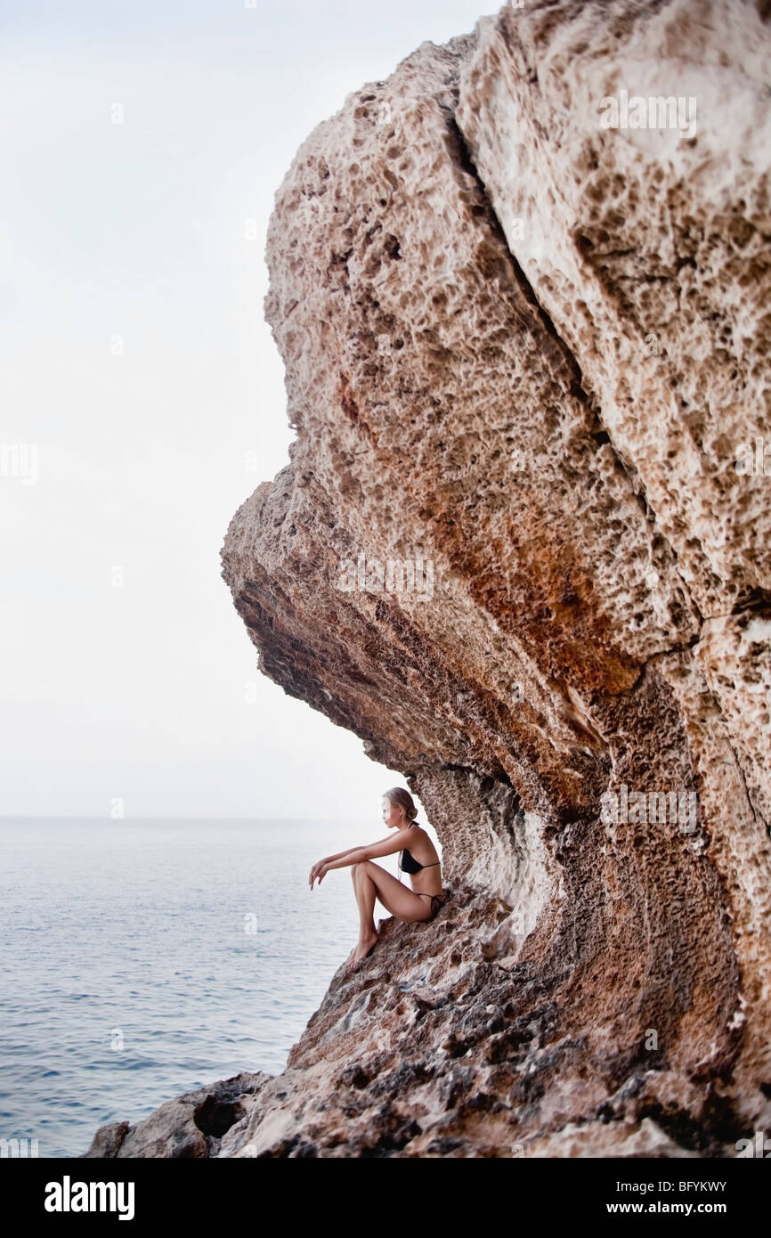 woman sitting on the rocks at cliffs Stock Photo - Alamy