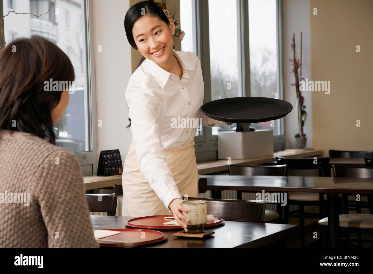 young japanese waitress serving guest at restaurant Stock Photo Alamy
