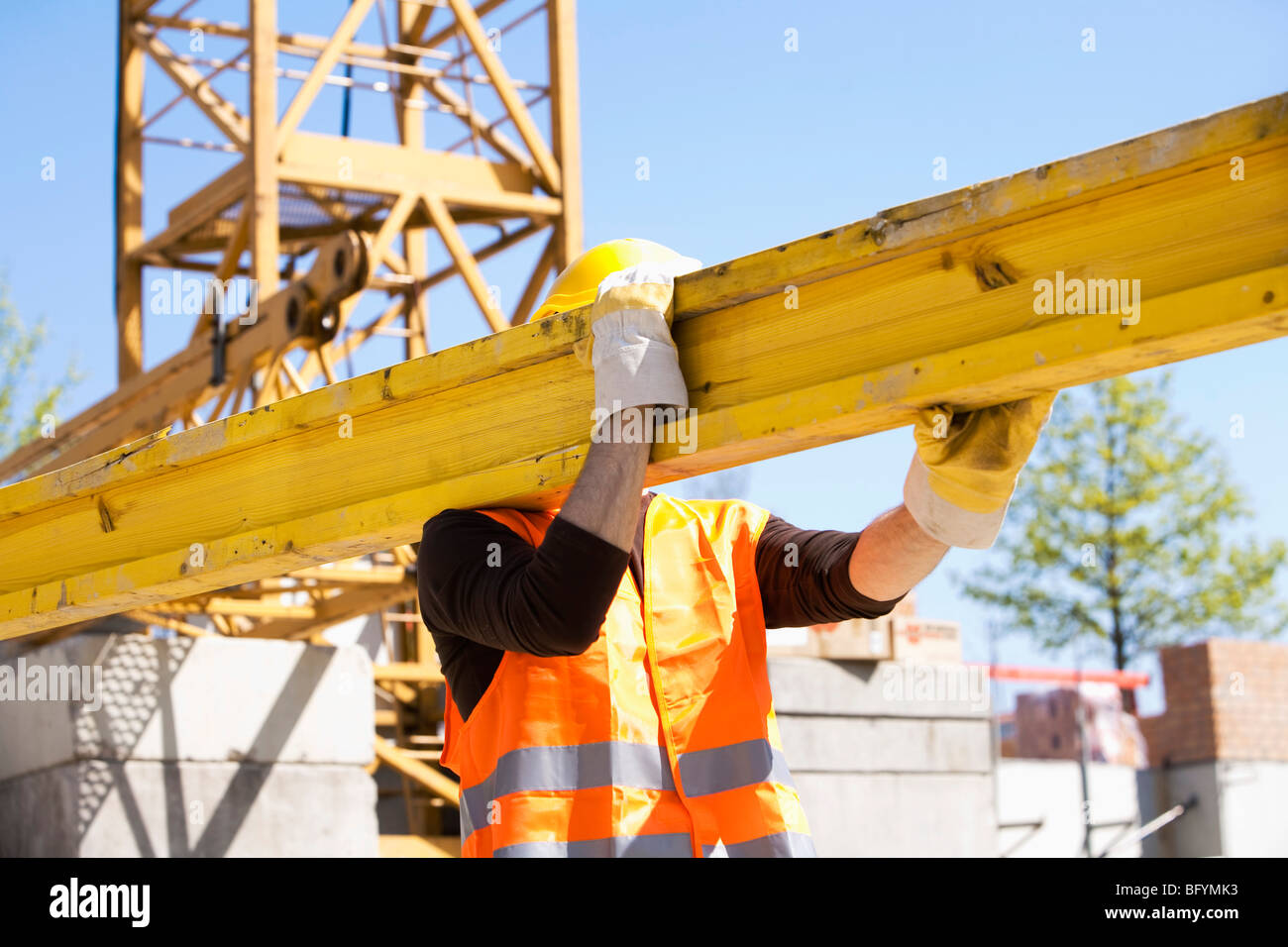construction worker carrying wooden plank Stock Photo - Alamy