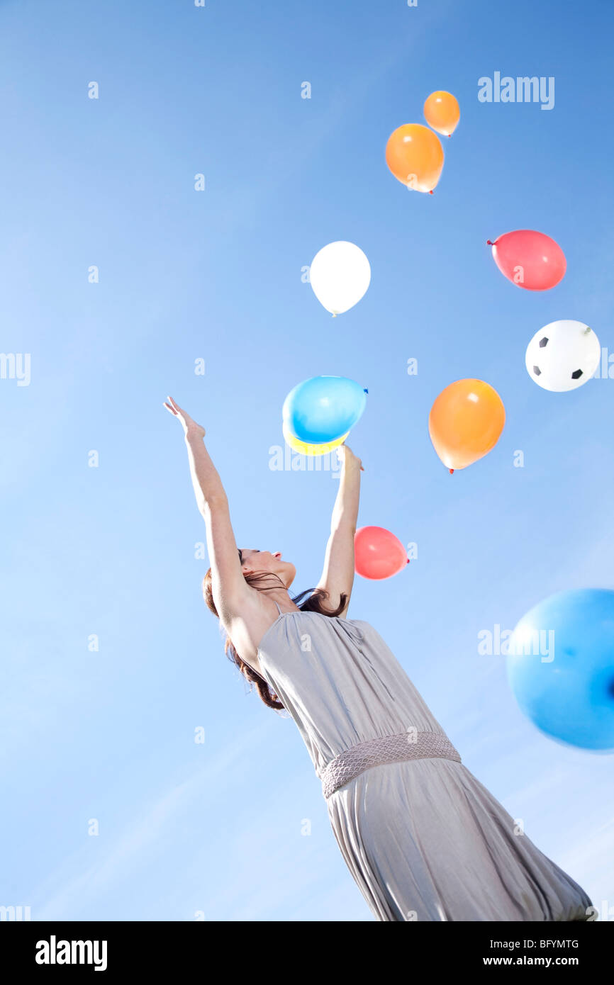 young woman letting balloons fly up in the sky Stock Photo - Alamy