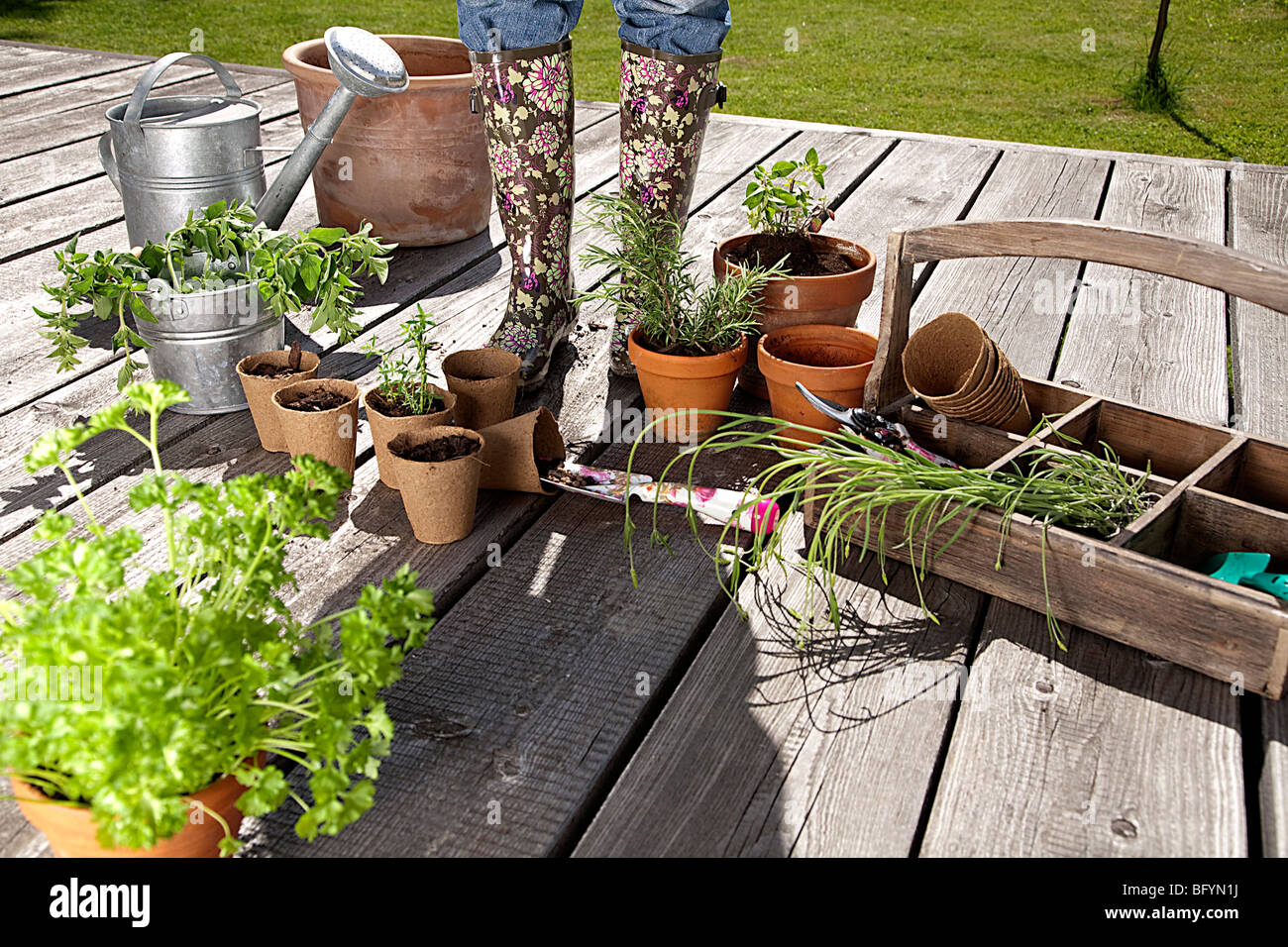 detail of young woman on veranda surrounded by gardening equipment Stock Photo
