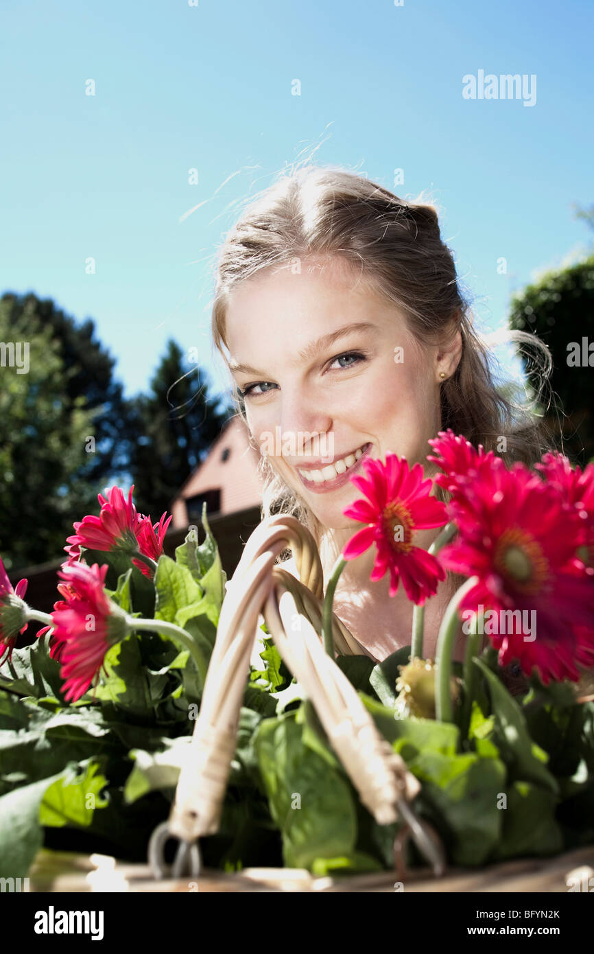 portrait of young woman with basket full of flowers Stock Photo - Alamy