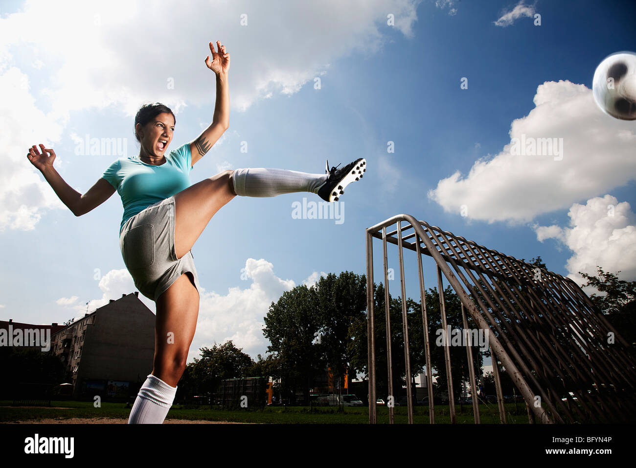 female football player kicking ball Stock Photo